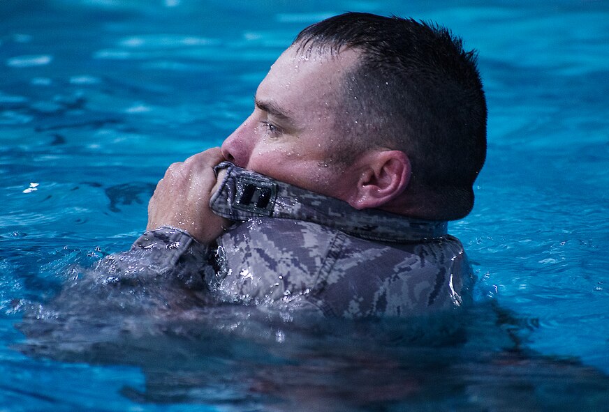 U.S. Air Force Capt. John Grucella, 93d Air Ground Operations Wing air liaison officer (ALO) aptitude assessment (AAA) Phase II program manager, demonstrates inflating his Airman Battle Uniform (ABU) top for floatation during an AAA for ALO candidates at Moody Air Force Base, Ga., March 19, 2014. Of the 38 candidates, 12 were considered to be water confident based on their performances during the various physical and mental challenges. (U.S. Air Force photo by Senior Airman Tiffany M. Grigg/Released) 
