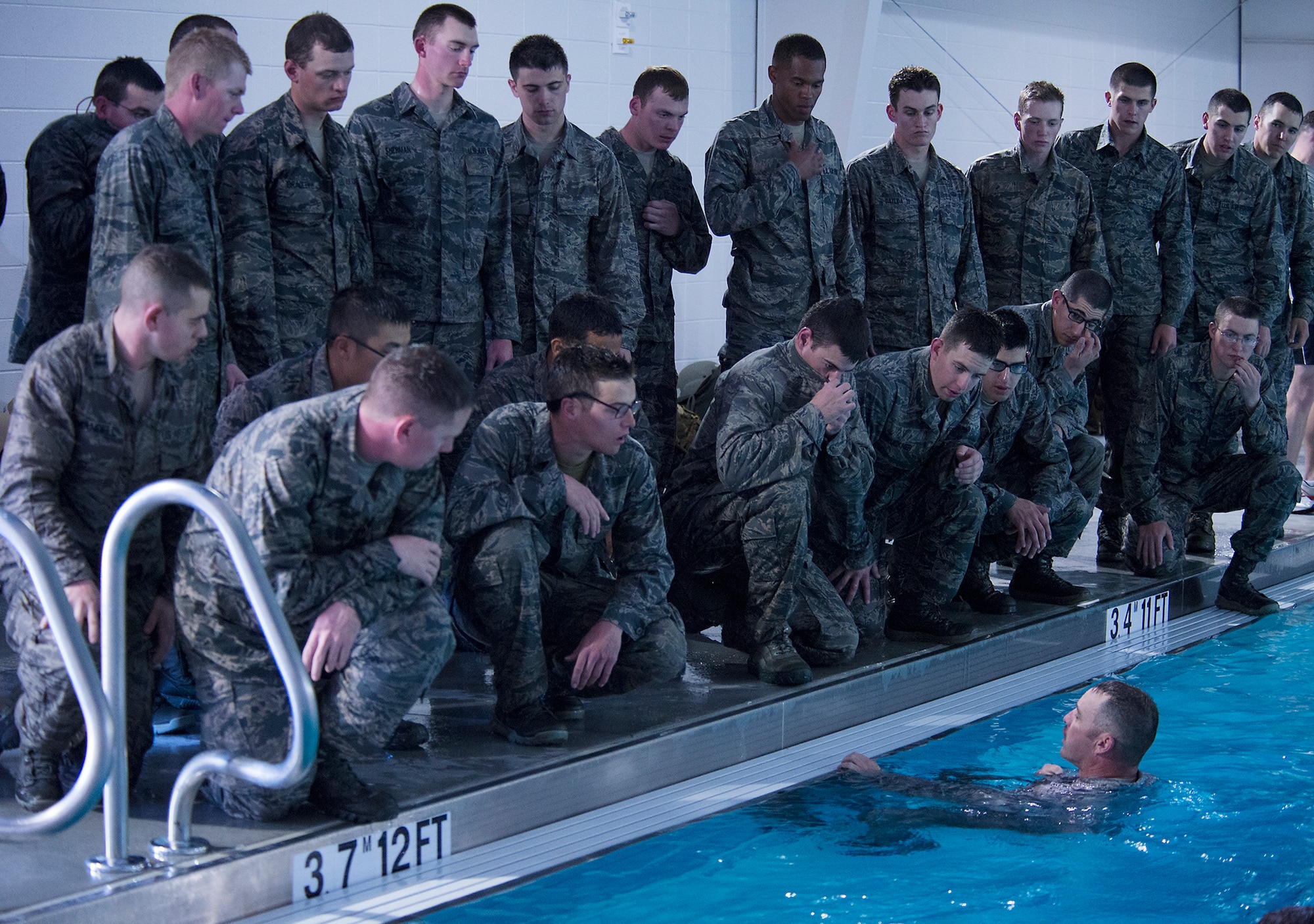 U.S. Air Force Capt. John Grucella, 93d Air Ground Operations Wing air liaison officer (ALO) aptitude assessment (AAA) Phase II program manager (bottom right), instructs ALO candidates on how to use their Airman Battle Uniform (ABU) top as a flotation device at Moody Air Force Base, Ga., March 19, 2014. During the AAA, the candidates experienced various physical and mental challenges to ensure their readiness for the ALO career field. (U.S. Air Force photo by Senior Airman Tiffany M. Grigg/Released) 