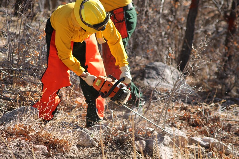 CHEYENNE MOUNTAIN AIR FORCE STATION, Colo. – Firefighters from the Cheyenne Mountain Air Force Station Fire Department remove ground fuels from the interior portion of the installation’s perimeter fence. The work is part of a Colorado Parks and Wildlife campaign to mitigate and reduce the risk of wildfires in the area and to help protect the communities and open spaces surrounding the mountain fortress. (U.S. Air Force photo/Michael Golembesky)