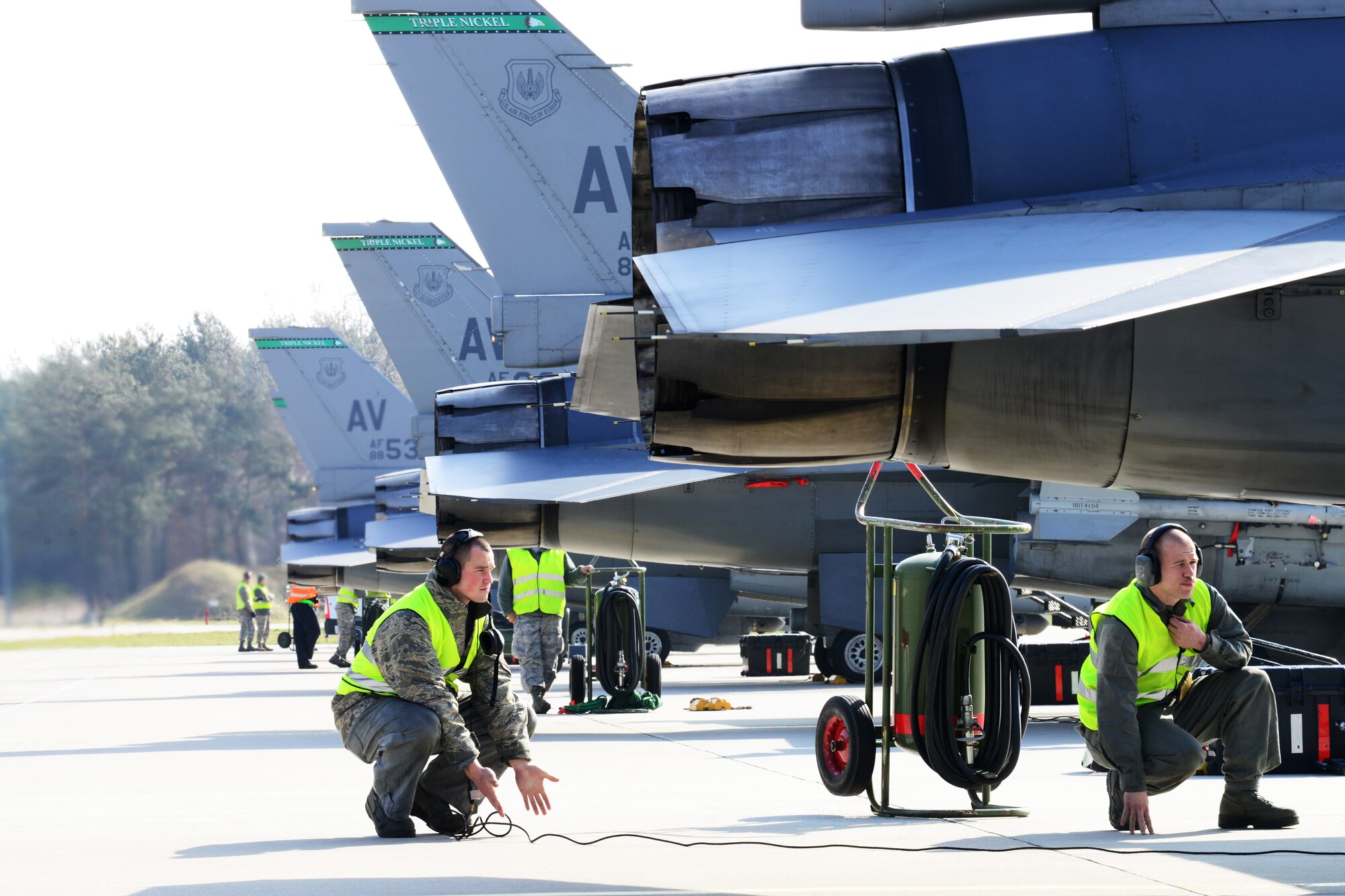 Airman 1st Class Tyler Hughes, 31st Aircraft Maintenance Squadron crew chief, signals to the pilot during pre-flight checks, March 20, 2014, at Łask Air Base, Poland. Throughout the past week, maintainers from the 31st AMXS, the 555th Aircraft Maintenance Unit and various other maintenance flights have worked together to maintain and repair F-16 Fighting Falcons involved with numerous training sorties. (U.S. Air Force photo/Airman 1st Class Ryan Conroy/Released) 