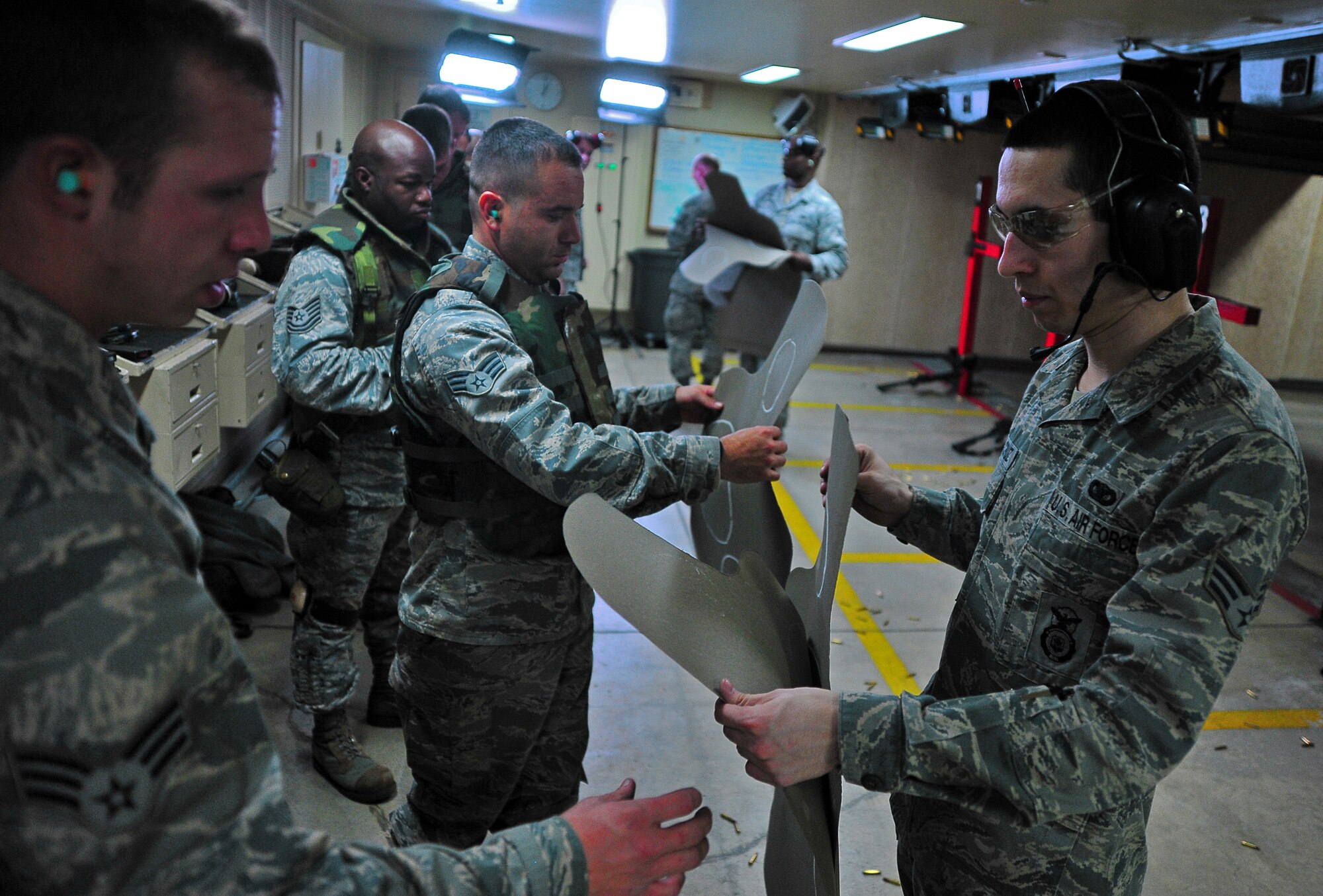 U.S. Air Force Senior Airman Anthony De La Cruz, 35th Security Forces Squadron point and range official, hands out target sheets to Airmen undergoing a qualification course at Misawa Air Base, Japan, March 20, 2014. As a Combat Arms Training and Maintenance team member, De La Cruz ensures the safety of the base shooting range. (U.S. Air Force photo/Senior Airman Jose L. Hernandez-Domitilo)