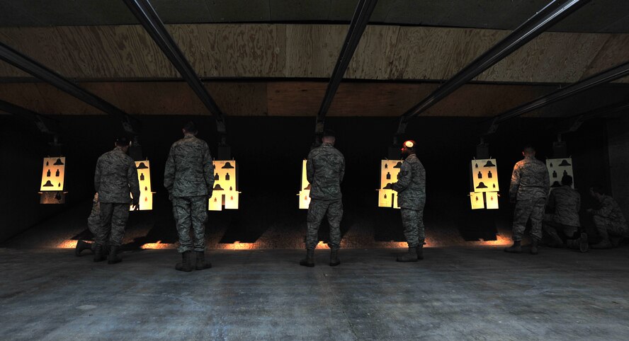 Airmen assigned to the 35th Maintenance Group review their firing target sheets with 35th Security Forces Squadron Combat Arms Training and Maintenance instructors following a qualification assessment at Misawa Air Base, Japan, March 20, 2014. Airmen must meet Air Force firearm qualification standards as part of a job requirement or deployment. (U.S. Air Force photo/Senior Airman Jose L. Hernandez-Domitilo)