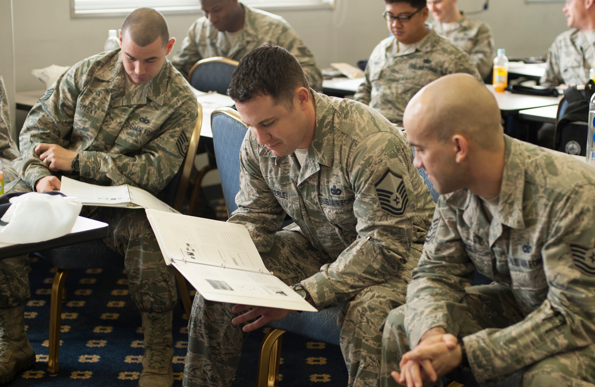 Center, Master Sgt. Roy Eberle, 35th Security Forces Squadron Misawa Air Base, Japan, looks at course material along with his peers during Defender’s Edge training at Yokota Air Base, Japan, Mar. 19, 2014. Defender’s Edge is a resiliency training, which is made for security forces Airmen by security forces Airmen. (U.S. Air Force photo by Senior Airman Desiree Economides)