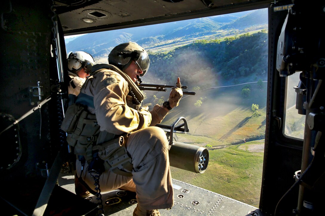 Marine Corps Sgt. Andrew Morey, foreground, directs Marine Corps Lance Cpl. Brooke Livingston as she engages a target with an M240G medium machine gun from a UH-1Y Huey helicopter during an urban training exercise on Fort Hunter Liggett, Calif., March 17, 2014. Morey and Livingston are crew chiefs assigned to 11th Marine Expeditionary Unit, Marine Medium Tiltrotor Squadron 163.