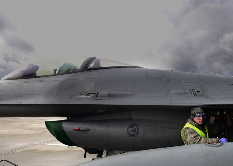 Airman 1st Class Tyler Hughes drains hydraulic fluid from an F-16 Fighting Falcon, March 19, 2014, at Lask Air Base, Poland. Throughout the past week, maintainers from the 31st AMXS, the 555th Aircraft Maintenance Unit and various other maintenance flights have worked together to maintain and repair F-16s involved with numerous training sorties. Hughes is a 31st Aircraft Maintenance Squadron crew chief. (U.S. Air Force photo/Airman 1st Class Ryan Conroy)