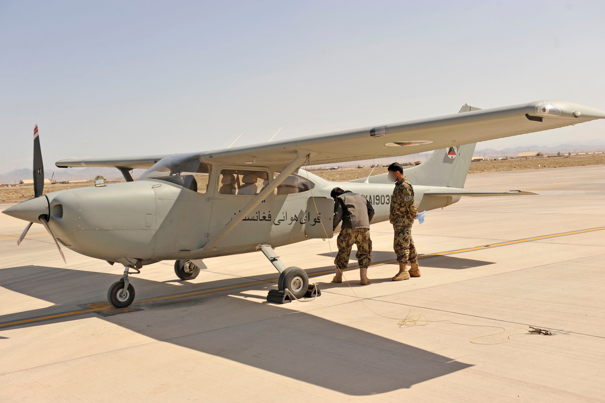 Two Afghan pilot students do a preflight check on a Cessna 182 at Shindand Airfield, Afghanistan, March 9, 2014. U.S. military advisors are training Afghan military members to fly and maintain aircraft at Shindand.(U.S. Air Force photo by Senior Master Sgt. Gary J. Rihn) (Faces blurred for security purposes)