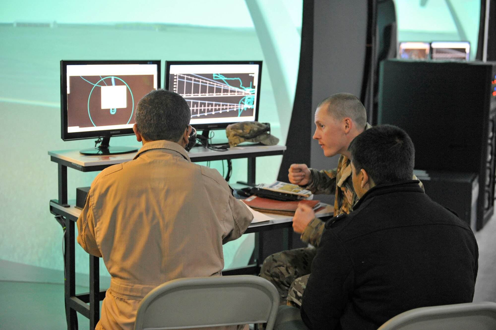 Capt. Justin Gripp of the 803rd Air Expeditionary Advisor Squadron  instructs an Afghan pilot student on approach techniques with the aid of a simulator and interpreter at Shindand Airfield, Afghanistan, March 10, 2014. U.S. military advisors are training Afghan military members to fly and maintain aircraft at Shindand.(U.S. Air Force photo by Senior Master Sgt. Gary J. Rihn)