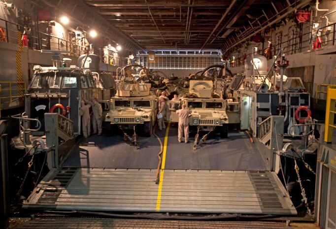 U.S. Marines with the 22nd Marine Expeditionary Unit (MEU) and U.S. Navy Sailors with Assault Craft Unit 4 prepare vehicles and equipment for transport on a landing craft, air cushion aboard the USS Mesa Verde (LPD 19) in support of an exercise. The 22nd MEU is deployed with the Bataan Amphibious Ready Group as a theater reserve and crisis response force throughout U.S. Central Command and the U.S. 5th Fleet area of responsibility. (U.S. Marine Corps photo by Staff Sgt. Lukas Atwell/Released)