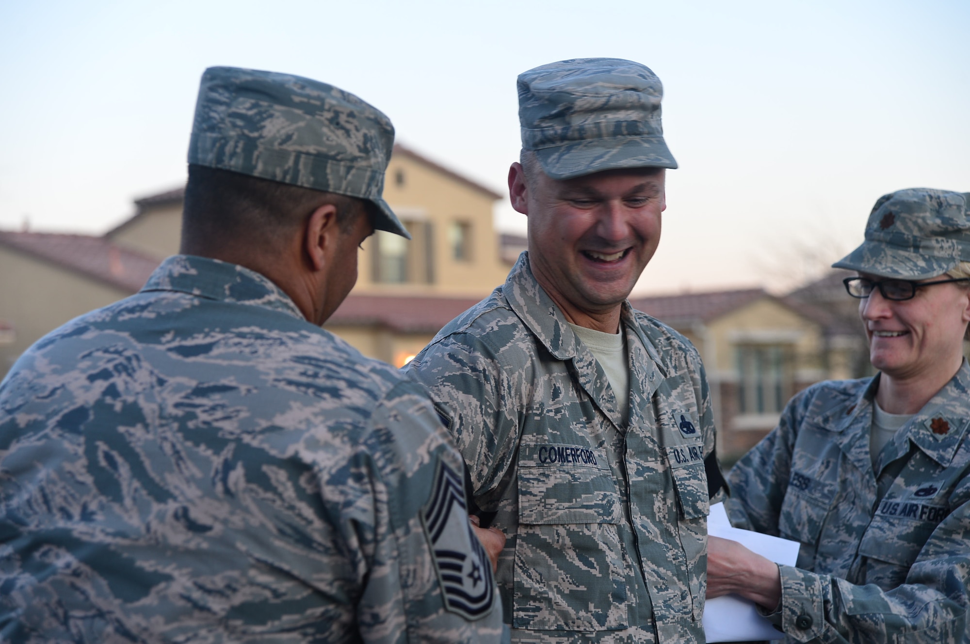 Chief Master Sgt. John, left, 432nd Maintenance Group and Maj. Seanna, 432nd Maintenance Squadron commander, pin on Master Sgt. Gordon, 432nd MXS accountable munitions systems officer, with his newly earned rank of senior master sergeant at his home.  Leadership from the 432nd Wing/432nd Air Expeditionary Wing made sure that Creech Air Force Base’s newest senior master sergeants and their families were personally recognized for their achievements with an unexpected visit at their home. (U.S. Air Force photo by Staff Sgt. N.B.)