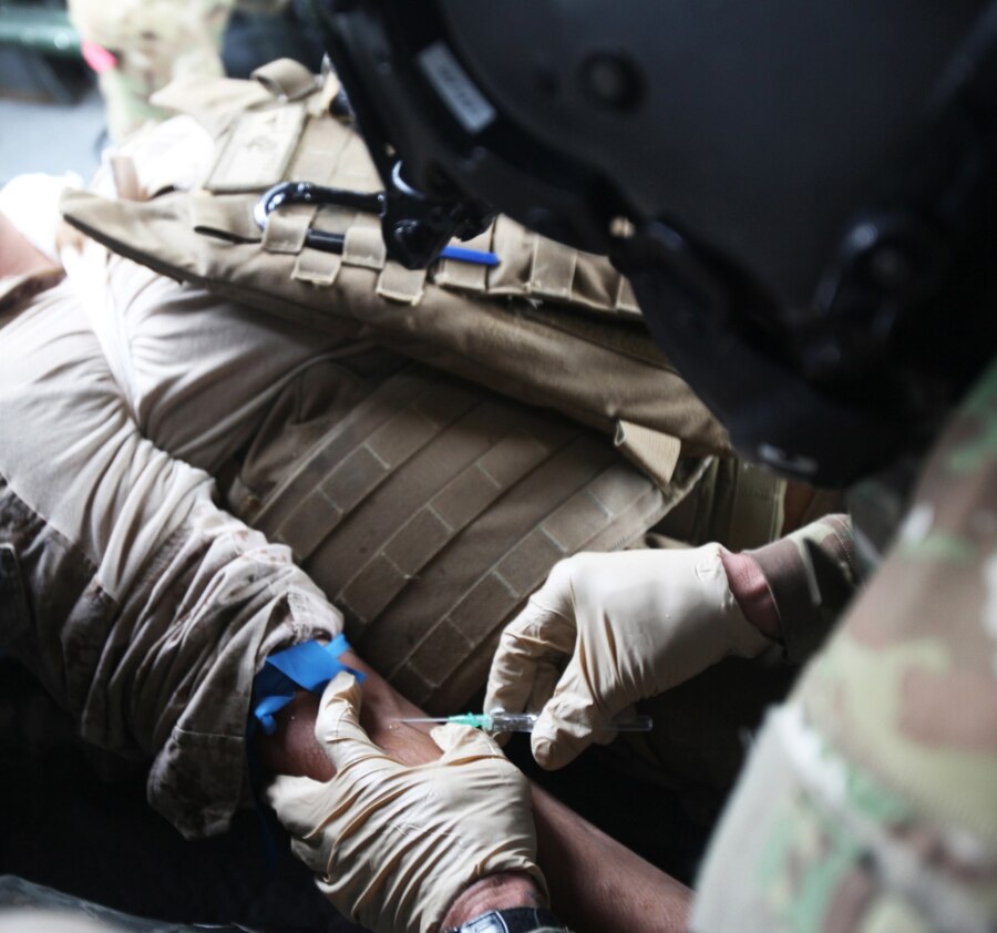 A flight medic with Golf Company, 2-135th General Support Aviation Battalion, draws blood from a simulated Marine casualty during a medical evacuation training exercise aboard Forward Operating Base Delaram II, Nimroz province, Afghanistan, March 14, 2014. Medevac crews operate out of FOB Delaram II in support of coalition forces patrolling in the surrounding area. (U.S. Marine Corps photo by Cpl. Cody Haas/ Released)