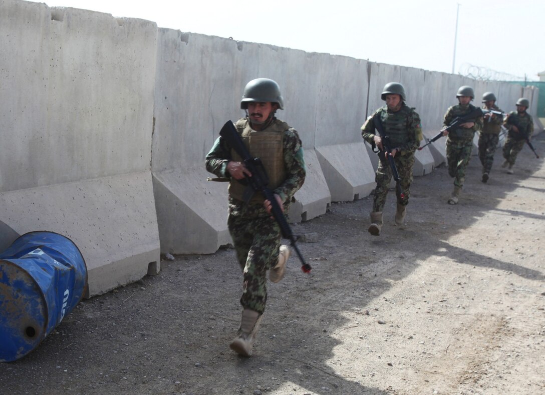 Soldiers with the 215th Corps, Afghan National Army, patrol alongside a barrier during a training course at Regional Corps Battle School aboard Camp Shorabak, Afghanistan, March 19, 2014. During the weeklong course, ANA soldiers with the 215th Corps learn proper techniques on how to forcefully enter an enemy-occupied building or compound, explosive ordnance disposal tactics and patrolling methods. (U.S. Marine Corps photo by Cpl. Cody Haas/ Released)