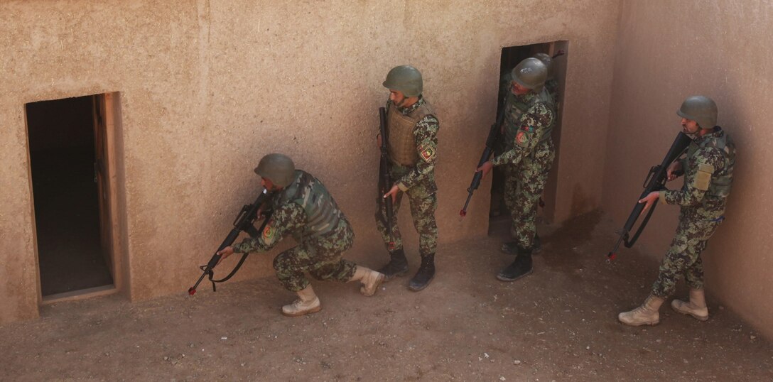 Soldiers with the 215th Corps, Afghan National Army, forcefully enter a simulated enemy-occupied compound during a training course at Regional Corps Battle School aboard Camp Shorabak, Afghanistan, March 19, 2014. During the weeklong course, ANA soldiers with the 215th Corps learn proper techniques on how to forcefully enter an enemy-occupied building or compound, explosive ordnance disposal tactics and patrolling methods. (U.S. Marine Corps photo by Cpl. Cody Haas/ Released)