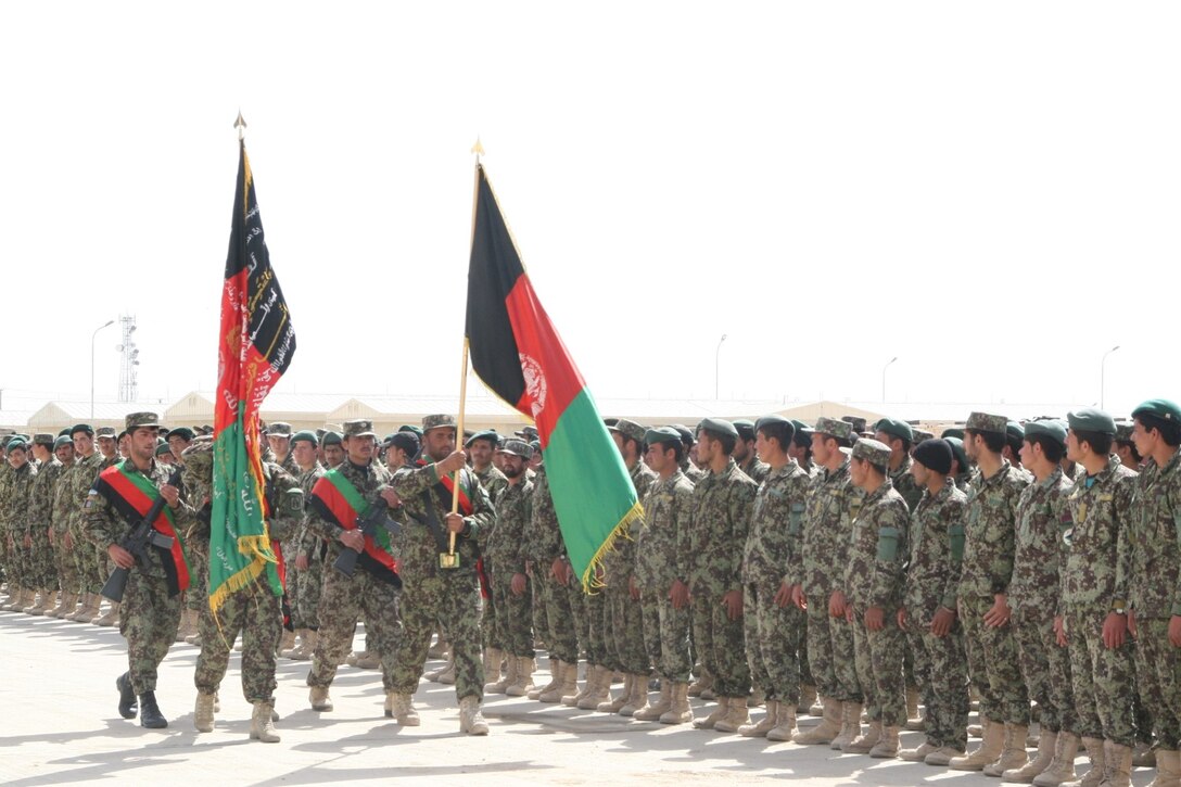 The Afghan National Army 215th Corps color guard marches past the formation during the Regional Corps Battle School graduation ceremony held aboard Camp Shorabak, Helmand province, Afghanistan, March 20, 2014. The training conducted at RCBS is Afghan-led, with Marines advising the Afghan instructors as needed.