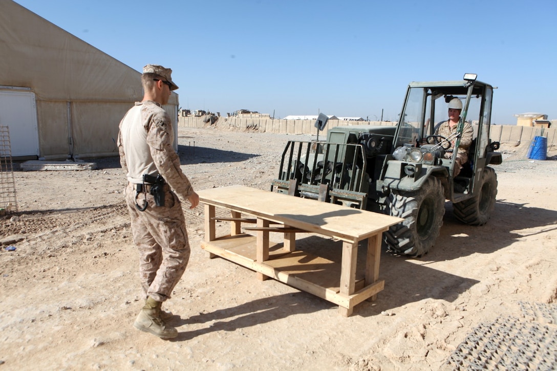 Navy Lt. jg. James M. Nicholson, left, the medical advisor for 2nd Brigade, 215th Corps, Afghan National Army, and Cpl. Timothy Smith, a team member with Security Force Assistance Advisor Team 2-215, deliver a table to Afghan medical staff aboard Forward Operating Base Nolay, Afghanistan, March 21, 2014. The table will increase casualty-care capacity and is the second of two tables delivered to the Afghan medics.