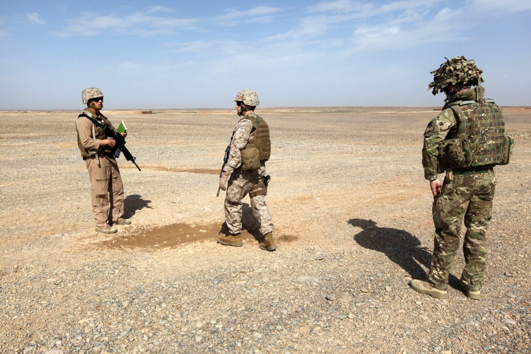 Captain Roger Collicott, left, the helicopter landing zone manager; Capt. Matt Blose, center, the safety officer, both with Marine Aircraft Group-Afghanistan; and Flight Lt. Seb Cannon, the Mobile Aviation Operations Team commander with Joint Aviation Group, conduct a helicopter landing zone study at Patrol Base Boldak, Helmand province, Afghanistan, March 20, 2014.  Landing zone studies are performed as often as possible in order to update requirements and the coordination needed to maintain the HLZ, as well as to ensure proper procedures and safety requirements are set in place. (USMC Photo By: Sgt. Frances Johnson/Released)