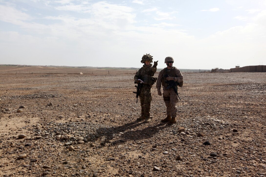 Flight Lt. Seb Cannon, left, the Mobile Aviation Operations Team commander with Joint Aviation Group, points out different terrain to Capt. Matt Blose, safety officer with Marine Aircraft Group-Afghanistan, while conducting an HLZ study aboard Patrol Base Boldak, Helmand province, Afghanistan, March 20, 2014. Landing zone studies are performed as often as possible in order to update requirements and the coordination needed to maintain the HLZ, as well as to ensure proper procedures and safety requirements are set in place. (USMC Photo By: Sgt. Frances Johnson/Released)