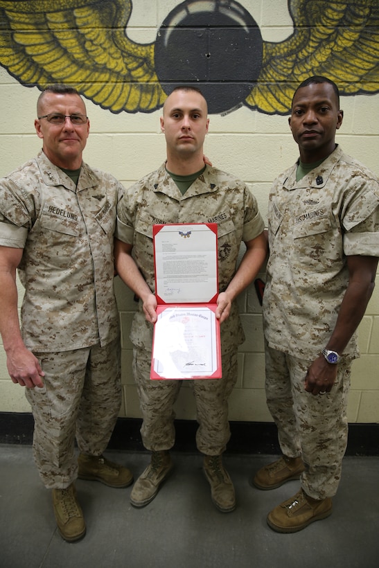Corporal Alexander D. Kuhn, center, stands next to Maj. Gen. Robert F. Hedelund, left, and Sgt. Maj. Christopher G. Robinson, right, March 25, 2014 at Marine Corps Air Station Cherry Point after receiving a Meritorious Mast for his volunteer efforts with the Congressional Medal of Honor Society's 2013 convention. Kuhn is an aviation ordnance technician with Marine Aviation Logistics Squadron 14, Hedelund is the commanding general of 2nd Marine Aircraft Wing and Robinson is the sergeant major of 2nd MAW. 
