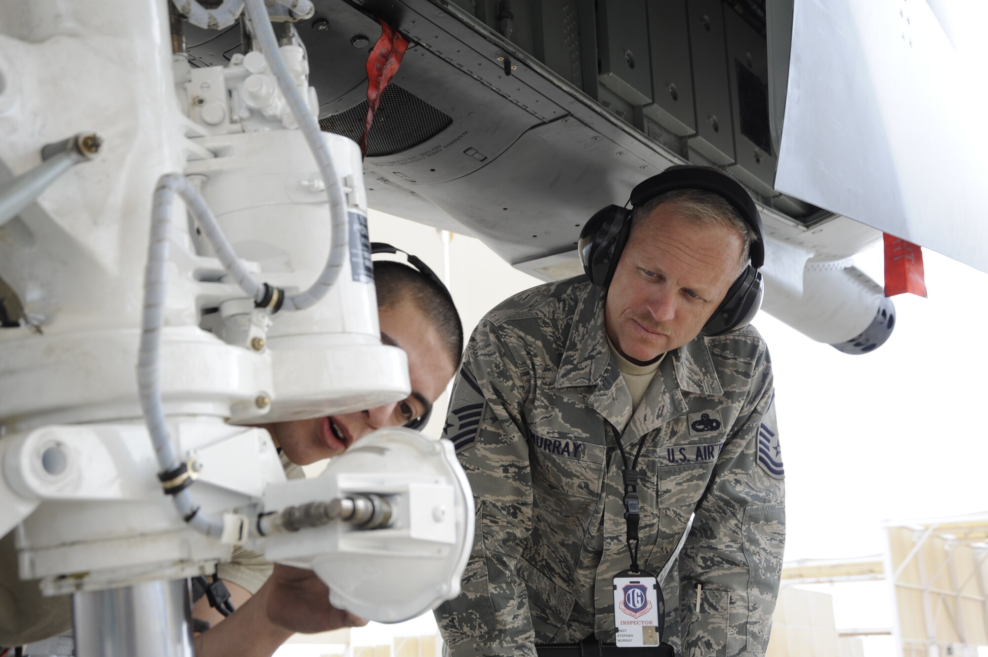 U.S. Air Force Master Sgt. Stephen Murray, Air Combat Command Inspector General inspector, observes Senior Airman Arrec Chetwood, 355th Aircraft Maintenance Squadron crew chief, as he checks the front tire of an A-10 Thunderbolt II at Davis-Monthan Air Force Base, Ariz., March 25, 2014. About 75 inspectors visited D-M to conduct a capstone for a unit effectiveness inspection. (U.S. Air Force photo by Airman 1st Class Betty R. Chevalier/released)