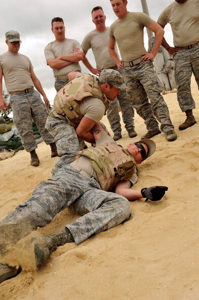 U.S. Air Force Tech. Sgt. Christopher Sakai, 18th Civil Engineer Squadron Heating, Ventilation, Air Conditioning and Refrigeration craftsman, throws Senior Airman Samuel Schwab, 18th CES HVACR journeyman, onto the ground during Defensive Fighting Position training on Torii Beach, Japan, March 20, 2014. The 18th CES conducts DFP training every two years to enhance Airmen's combat capability in a similar environment. (U.S. Air Force photo by Naoto Anazawa)