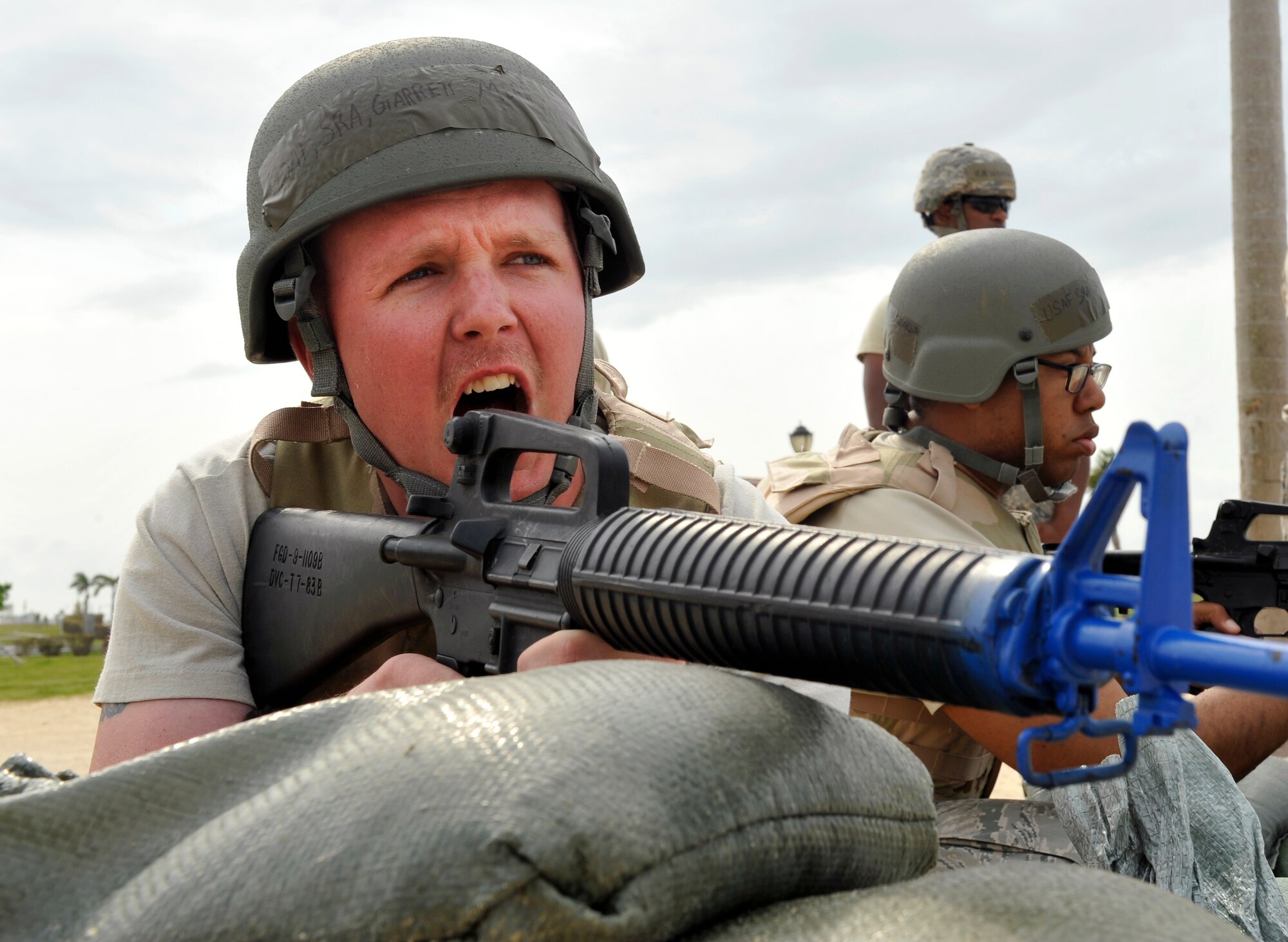 U.S. Air Force Senior Airman Garrett Merryman, 18th Civil Engineer Squadron Heating, Ventilation, Air Conditioning and Refrigeration journeyman, warns a simulated suspicious person during Defensive Fighting Position training on Torii Beach, Japan, March 20, 2014. The training, which the 18th CES conducts every two years, teaches Airmen how to protect themselves, improve their combat capability and prepare them for future contingencies. (U.S. Air Force photo by Naoto Anazawa)