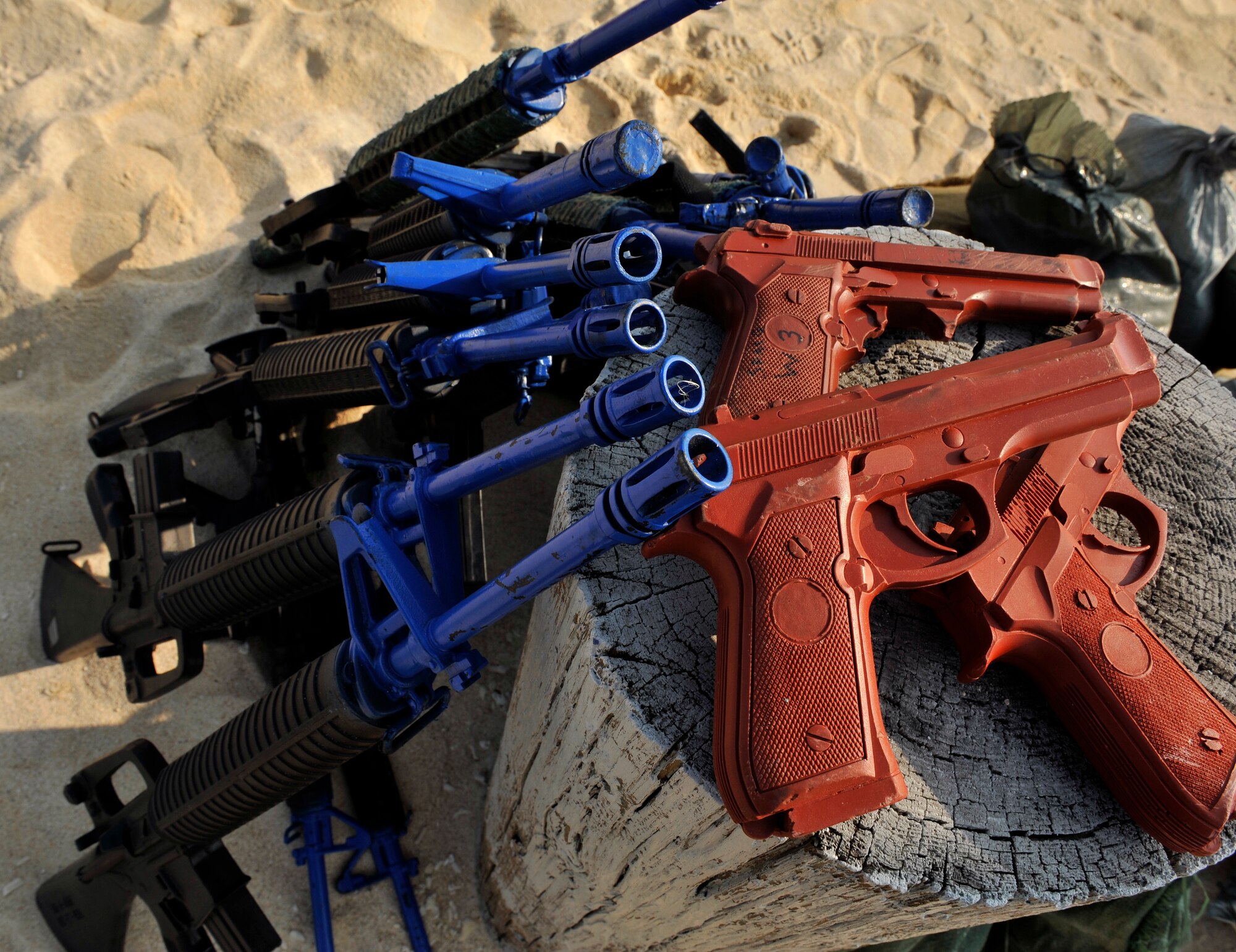 Members of the 18th Civil Engineer Squadron prepare rubber M-16 A2 rifles and M-9 pistols for Defensive Fighting Position training on Torii Beach, Japan, March 20, 2014. This training teaches Airmen how to protect themselves, improve their combat capability and prepare them for future contingencies. The 18th CES also conducts training for land navigation, night operations and individual movement. (U.S. Air Force photo by Naoto Anazawa)