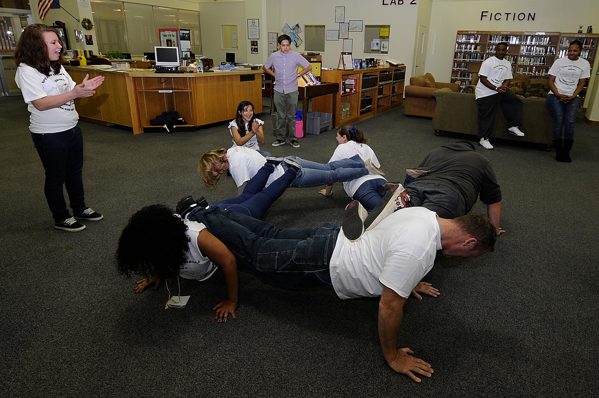 High school students and volunteers use teamwork to do a five-person push-up during Operation Snowball at Kadena High School on Kadena Air Base, Japan, March 22, 2014. Volunteers worked with the students from 8 a.m. to 3:30 p.m., teaching them about alcohol, tobacco, drug and sexual assault prevention, along with how to effectively communicate and not be a bystander. (U.S. photo by Senior Airman Marcus Morris)
