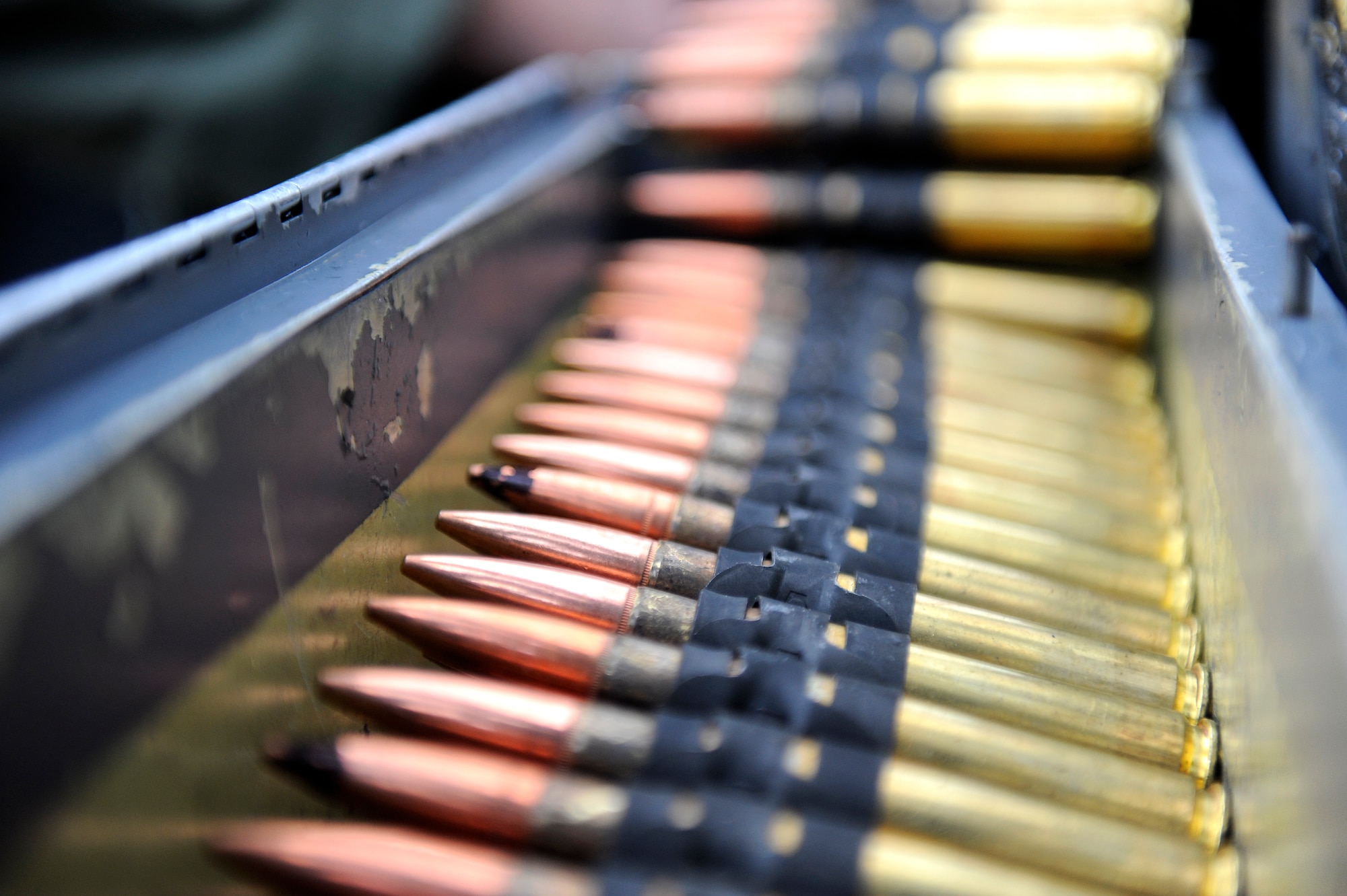 Rounds from a .50 caliber machinegun are loaded into a U.S. Air Force HH-60G Pave Hawk helicopter before a training mission on Kadena Air Base, Japan, March 20, 2014. During the training, members of the 33rd RQS performed an array of maneuvers and procedures to include hoist and .50 caliber machinegun training. (U.S. Air Force photo by Senior Airman Maeson L. Elleman)