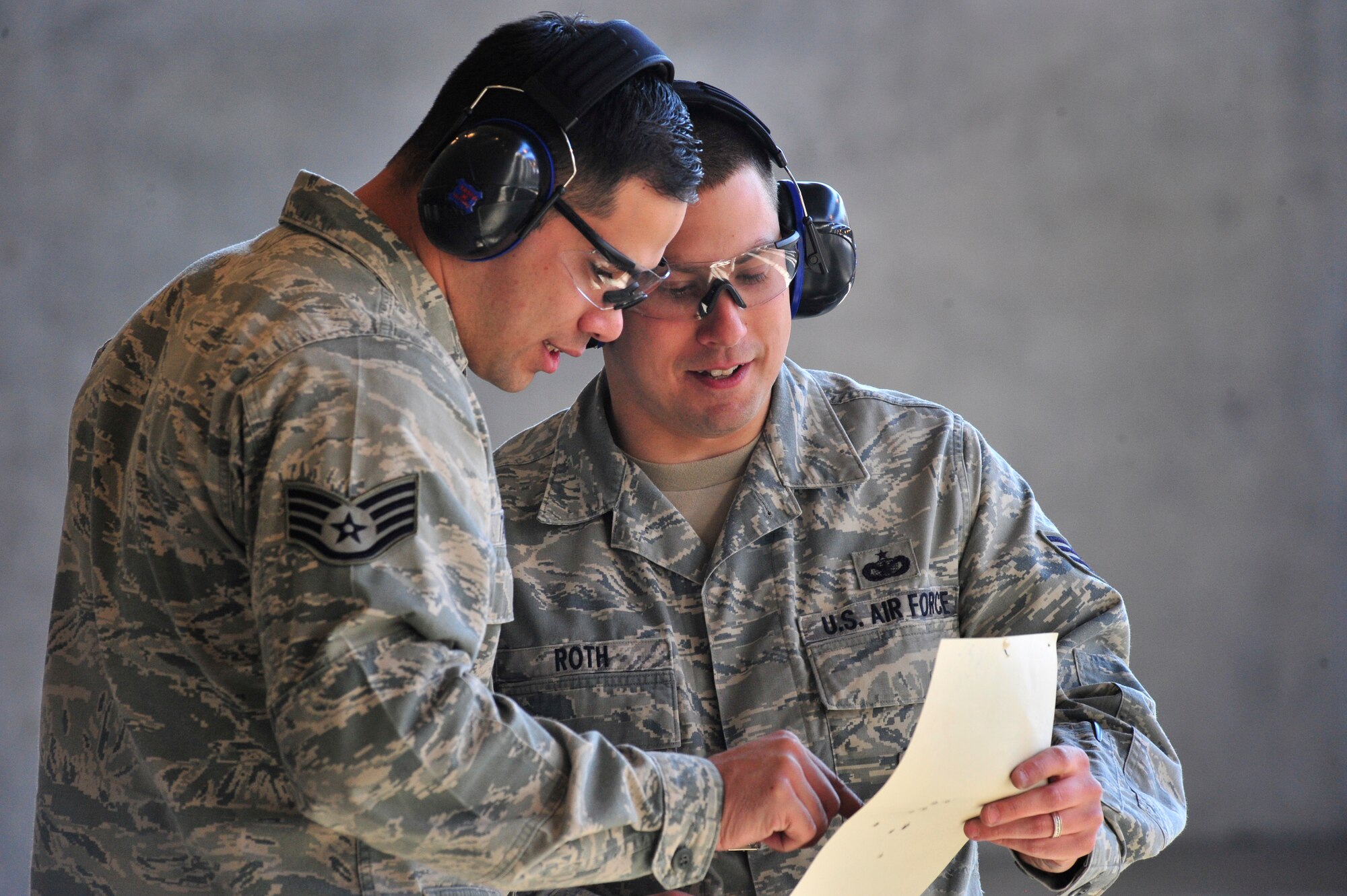 Staff Sgt. Steven Tayfel, 436th Security Forces Squadron raven trainer, and Staff Sgt. Michael Roth, 436th SFS electronic security systems NCO, show each other their targets during an Excellence in Competition rifle match March 21, 2014, at Dover Air Force Base, Del. Target distance for the match was 25 meters using an olympic six-10 ring range scoreable target with hits in the seven-10 ring counted for score. (U.S. Air Force photo/Staff Sgt. Elizabeth Morris)