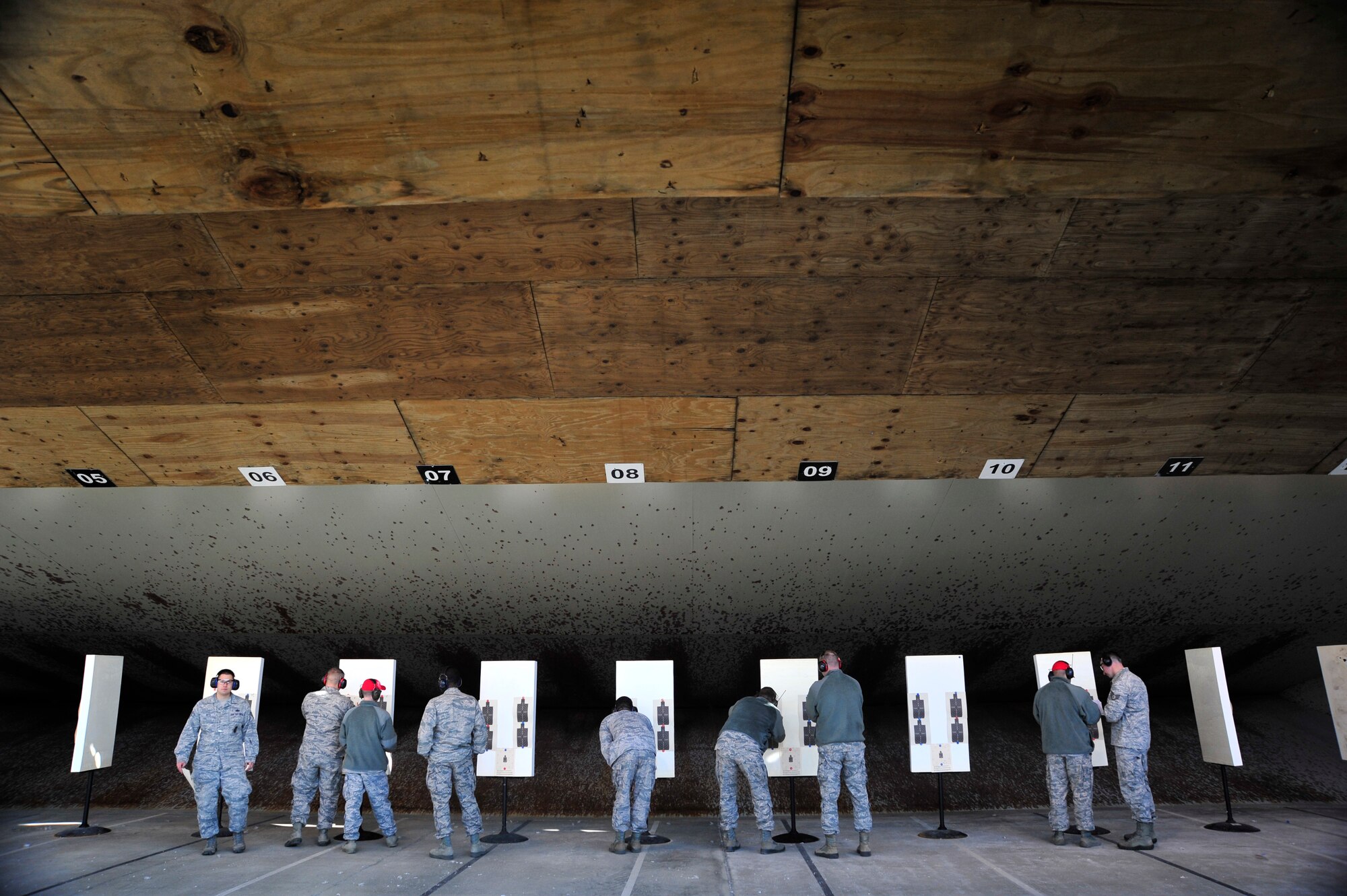 Participants in an Excellence in Competition rifle match stand by as 436th Security Forces Squadron combat arms instructors score their targets March 21, 2014, at Dover Air Force Base, Del. To earn a medal at the EIC match, shooters must have scored at least 455 out of 500 points and have a score in the top 10 percent of all shooters that participated. (U.S. Air Force photo/Staff Sgt. Elizabeth Morris)