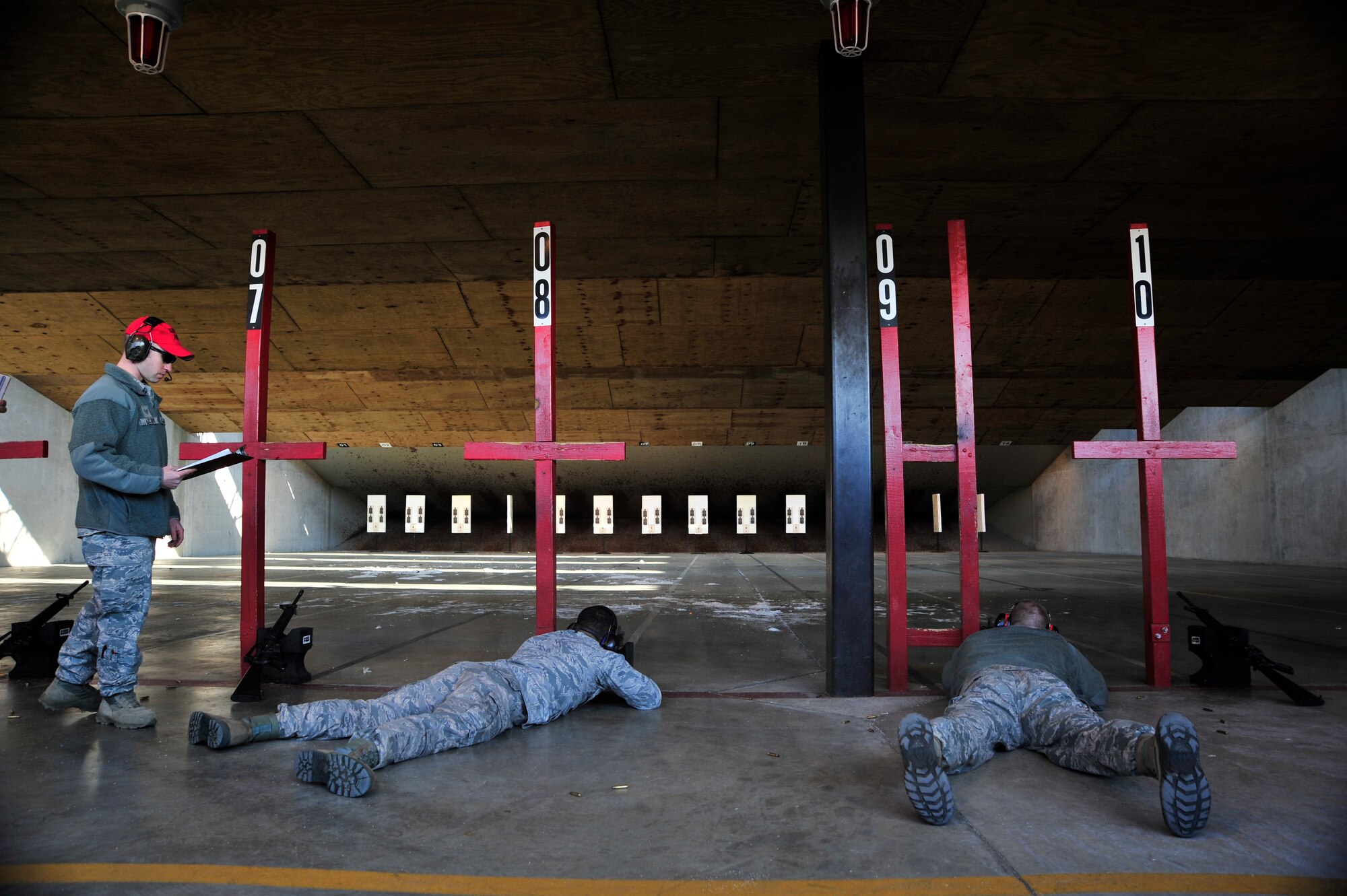Staff Sgt. Nick Leloux, 436th Security Forces Squadron combat arms instructor, watches two military members as they participate in an Excellence in Competition rifle match March 21, 2014, at Dover Air Force Base, Del. The rifle match was sponsored by the 436th Security Forces Squadron. (U.S. Air Force photo/Staff Sgt. Elizabeth Morris)