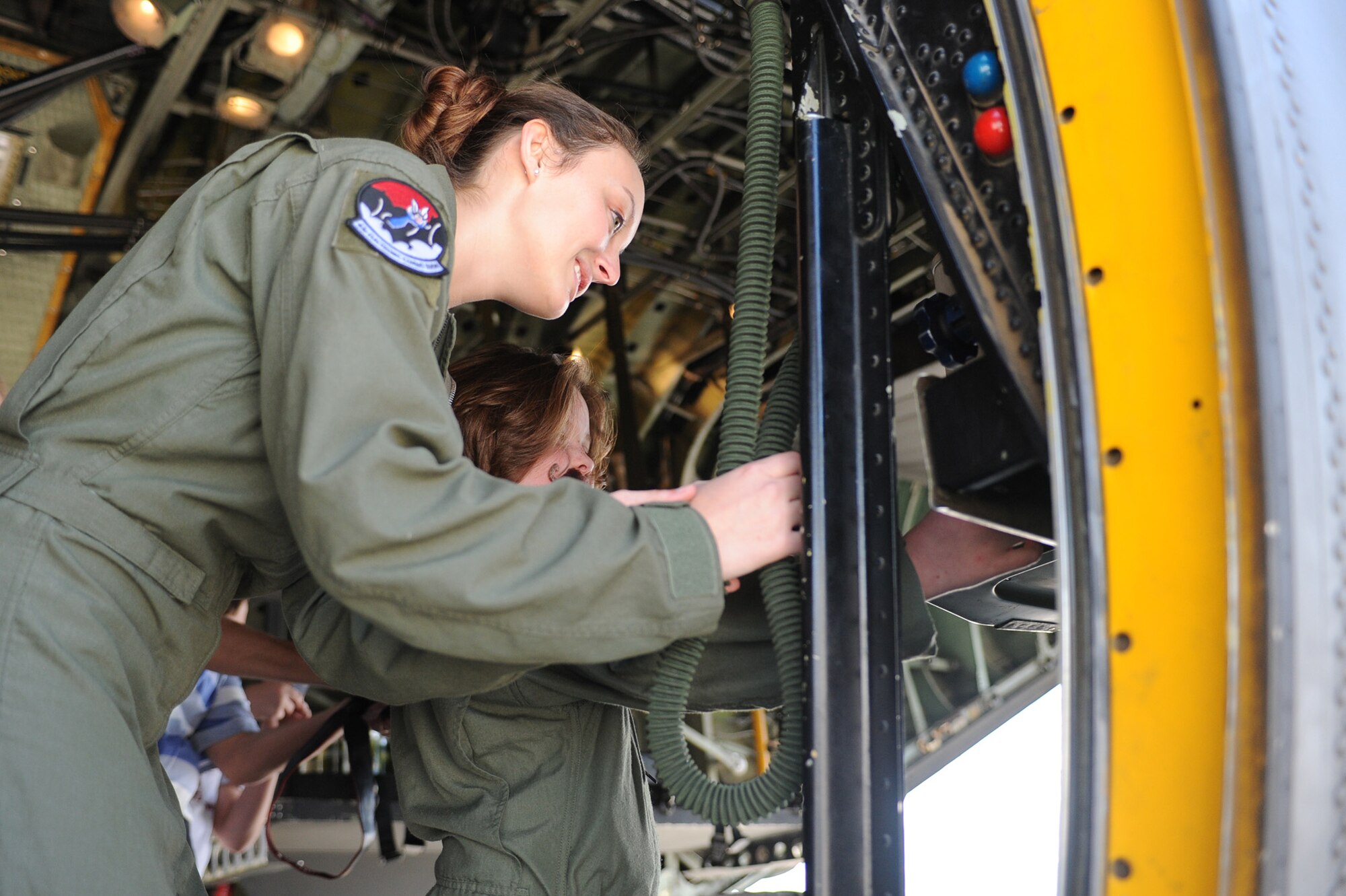 U.S. Air Force Senior Airman Heather Burdette, 43rd Electronic Combat Squadron, shows Dana Morgan, nine-year-old honorary Pilot for a Day, how to close the back ramp of an EC-130H Compass Call at Davis-Monthan Air Force Base, Ariz., March 14, 2014.  Morgan was sworn in as an honorary Pilot for a Day and given a flight suit, pilot wings and patches from the 43rd ECS.  (U.S. Air Force Photo by Airman 1st Class Chris Massey/Released)