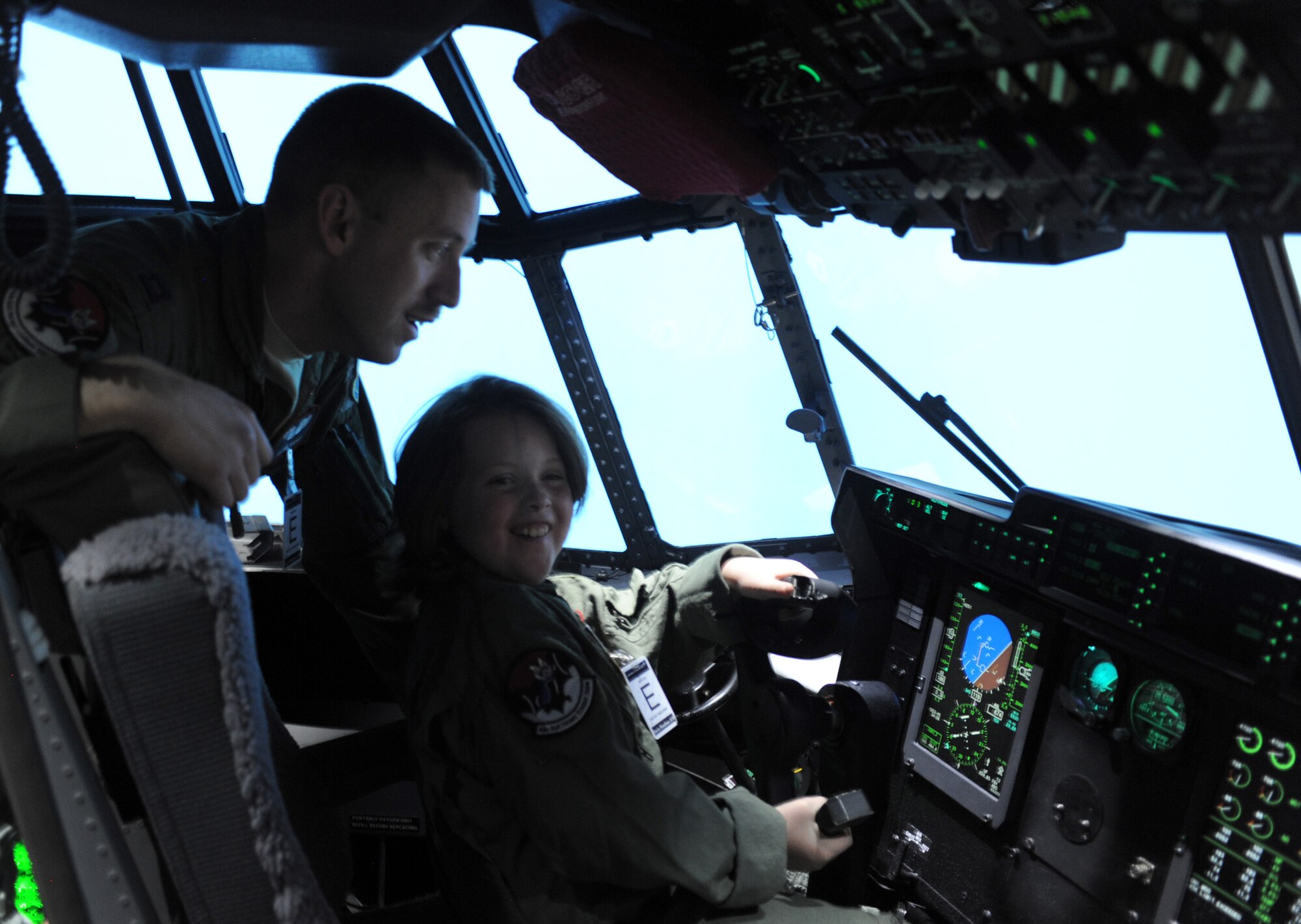 U.S. Air Force Capt. Bryan Kapes, 43rd Electronic Combat Squadron, instructs Dana Morgan, honorary 43rd ECS Pilot for a Day, inside an HC-130J Simulator at Davis-Monthan Air Force Base, Ariz., March 14, 2014. Morgan and her family were escorted by Kapes, whose unit hosted the Pilot for a Day tour.  (U.S. Air Force Photo by Airman 1st Class Chris Massey/Released)