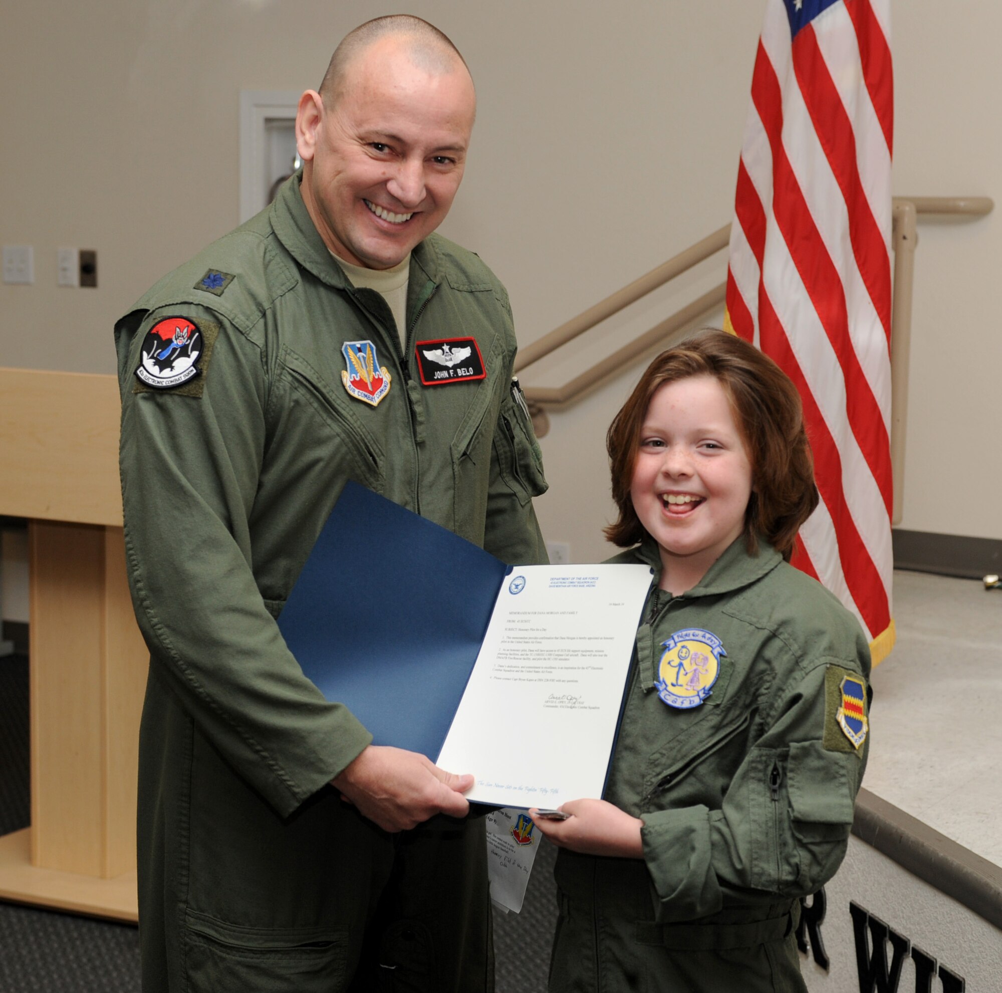 U.S. Air Force Lt. Col. John Belo, 43rd Electronic Combat Squadron director of operations, presents Dana Morgan, honorary Pilot for a Day, with an honorary pilot appointment letter at Davis-Monthan Air Force Base, Ariz., March 14, 2014.  Each honorary pilot leaves D-M with patches, souvenirs and memories to help sustain them in the face of their personal challenges.  (U.S. Air Force Photo by Airman 1st Class Chris Massey/Released)