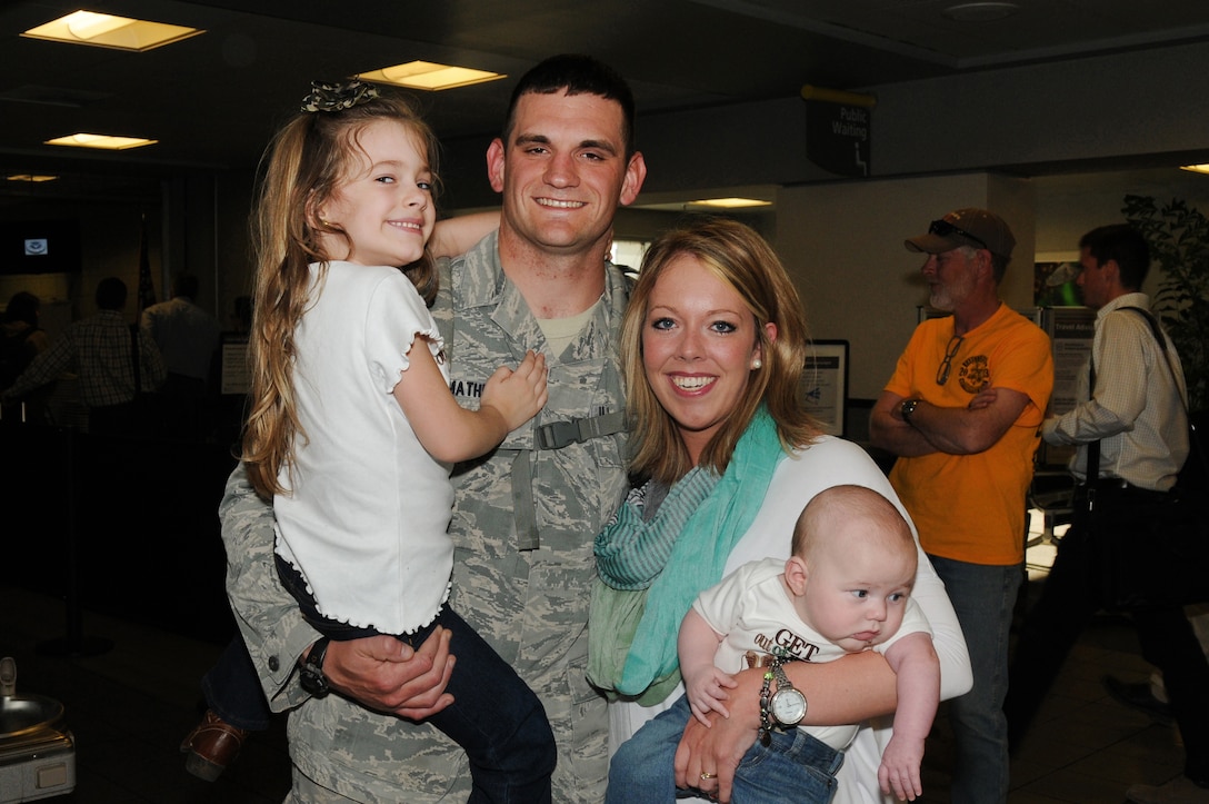 U.S Air Force Senior Airman Ronald L. Mathews with the 186th Air Refueling Wing, Security Forces Squadron poses for a photo with his wife, Megan, daughter, Abigail, and son, Mason, at the Jackson-Evers International Airport, Thursday, March 20, 2014, after a seven-month deployment to Southwest Asia.(U. S. Air National Guard photo by Senior Master Sgt. Richard Davis/Released)