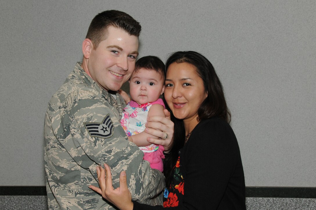 U.S Air Force Staff Sgt. Taylor S. McNamee with the 186th Air Refueling Wing, Security Forces Squadron and his wife, Latanya, hold their daughter, Mackenzie, for the first time at the Jackson-Evers International Airport, March 20, 2014, after a seven-month deployment to Southwest Asia. (U. S. Air National Guard photo by Senior Master Sgt. Richard Davis/Released)