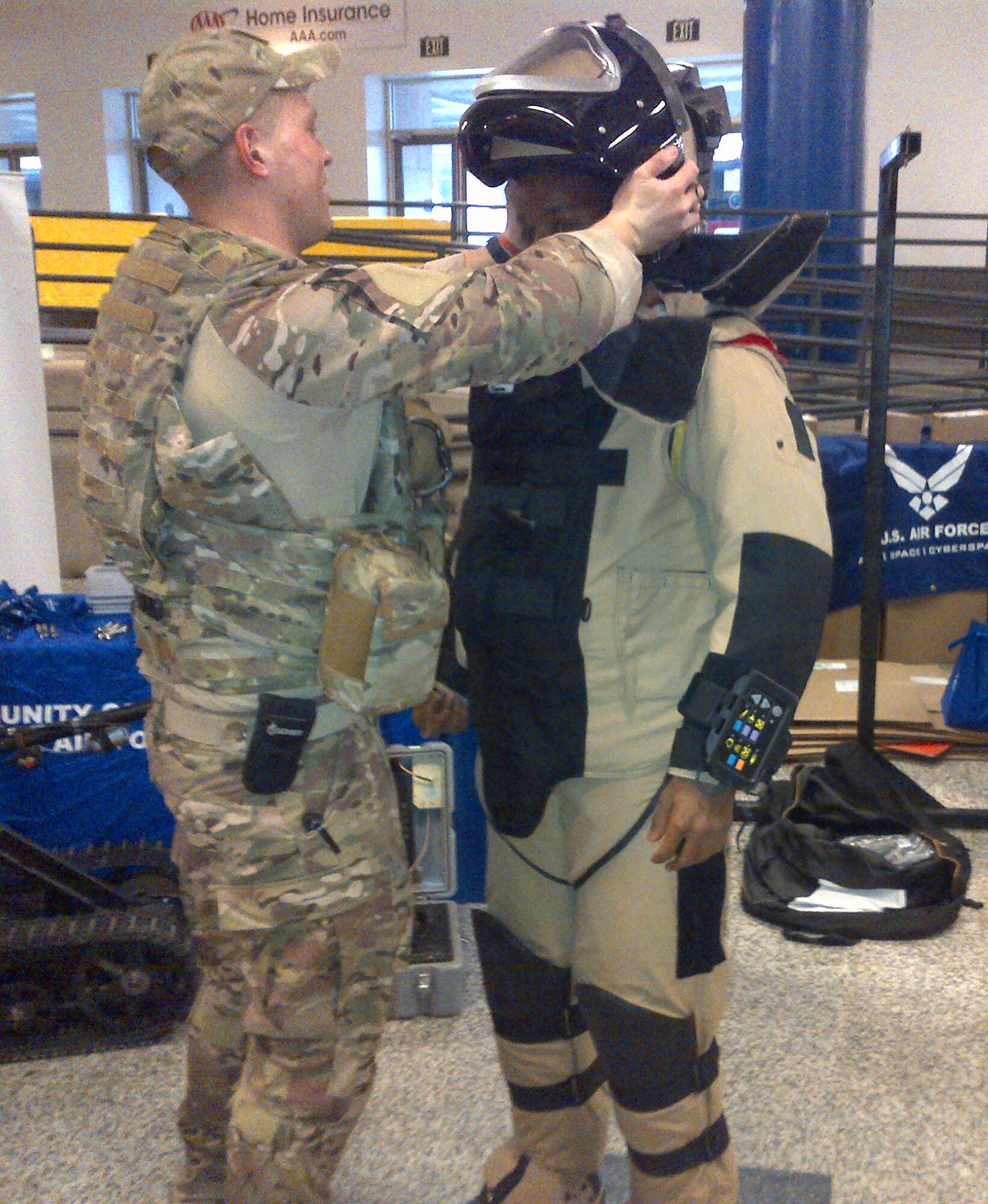 Airman 1st Class Brandon Thomas helps a perspective applicant don the EOD-9 bomb suit. (U.S. Air Force photo/Lt. Col. Sharon Presley)