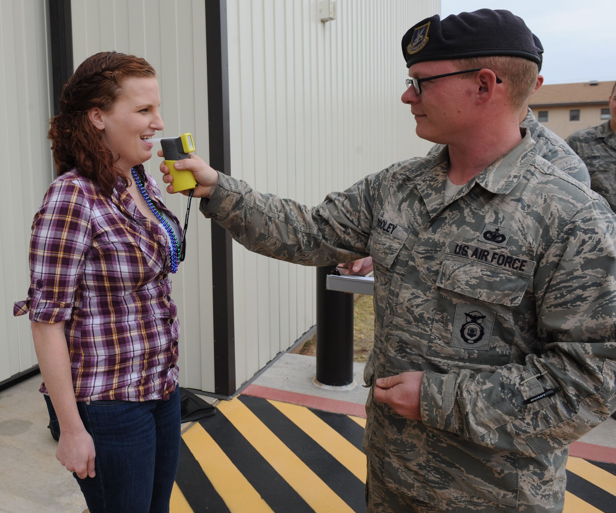 U.S. Air Force Airman 1st Class Teara Sapp (left), 40th Airlift Squadron, blows in a Breathalyzer held by Staff Sgt. Thomas Dooley, 7th Security Forces Squadron, March 21, 2014, at Dyess Air Force Base, Texas. Team Dyess is focusing on the mental domain of the Comprehensive Airman Fitness program. This involves being aware of how personal beliefs and values can affect behavior and concentrates on good decision making. This particular event focused on making good decisions when it comes to drinking and driving. (U.S. Air Force photo by Airman 1st Class Autumn Velez/Released)
