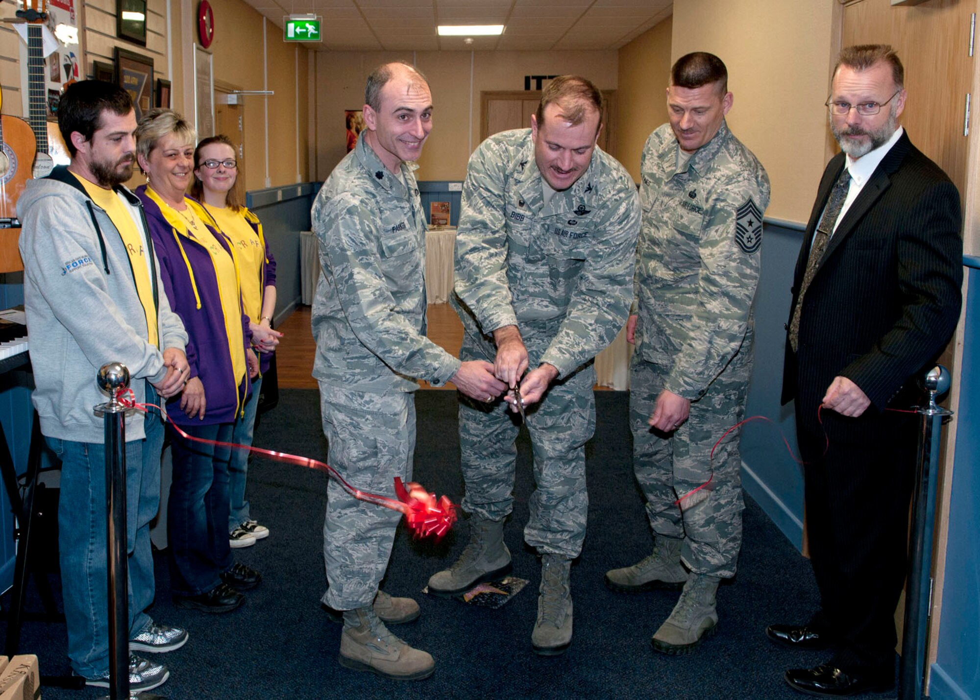 U.S. Air Force Col. Kenneth T. Bibb Jr., 100th Air Refueling Wing commander, center, cuts the ribbon at the grand opening of the 100th Force Support Squadron Arts and Crafts Center March 25, 2014, at the Bob Hope Community Center on RAF Mildenhall, England, while surrounded by 100th ARW leaders and 100th FSS staff. The new arts and crafts center's hours of operation are 9 a.m. to 4 p.m. Monday to Friday. The store offers a wide variety of services to customers, including making license plates, custom framing, embroidery and engraving. (U.S. Air Force photo by Karen Abeyasekere/Released)