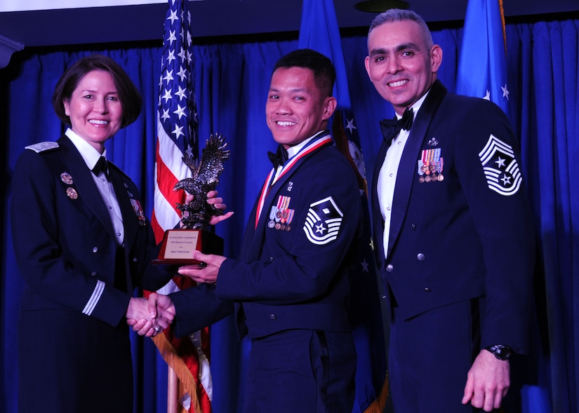Master Sgt. Tran Pham accepts the 2013 Air Force District of Washington Annual Awards First Sergeant of the Year trophy from AFDW Commander Maj. Gen. Sharon K. G. Dunbar and AFDW Command Chief Master Sgt. Jose LugoSantiago during the awards ceremony at Joint Base Anacostia-Bolling, D.C., March 21, 2014. Pham is the 11th Wing, 811th Security Forces Squadron first sergeant. (U.S. Air Force photo/Master Sgt. Tammie Moore) 