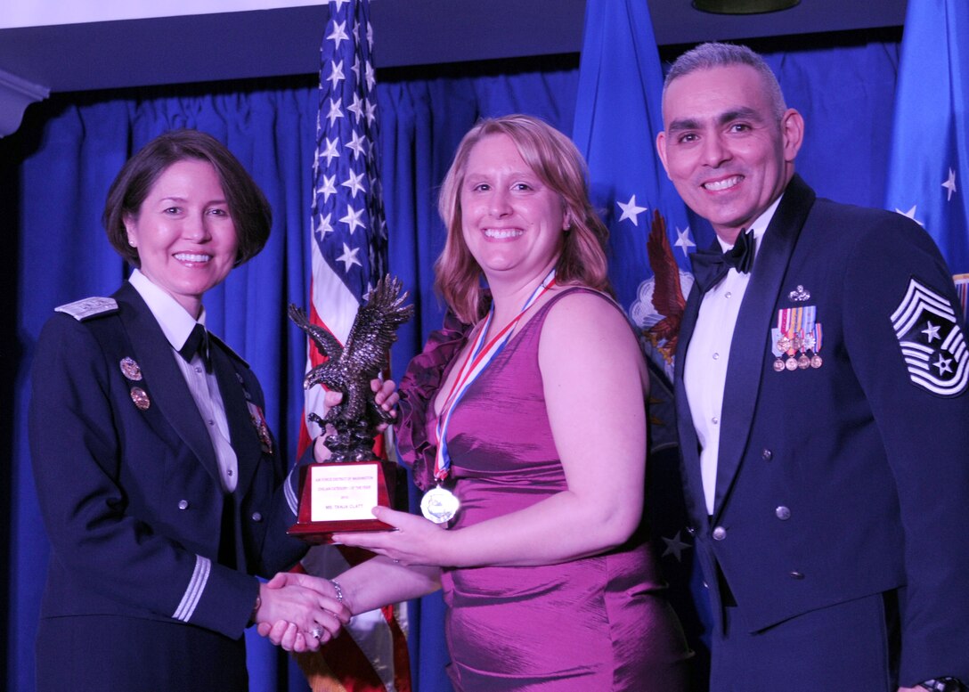 Tanja Clyatt accepts the 2013 Air Force District of Washington Annual Awards Civilian Category I of the Year trophy from AFDW Commander Maj. Gen. Sharon K. G. Dunbar and AFDW Command Chief Master Sgt. Jose LugoSantiago during the awards ceremony at Joint Base Anacostia-Bolling, D.C., March 21, 2014. Clyatt is the AFDW A6 secretary. (U.S. Air Force photo/Master Sgt. Tammie Moore) 