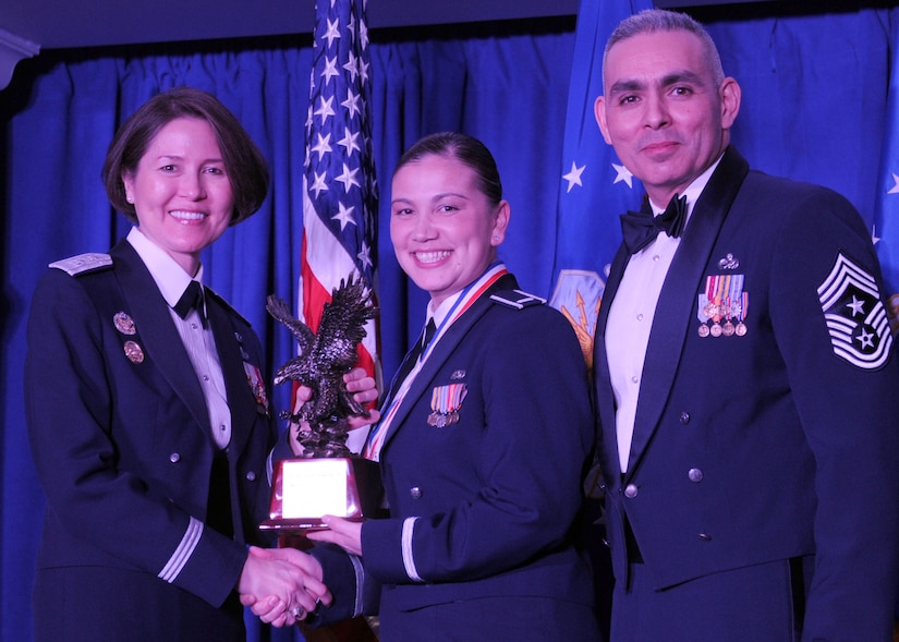 First Lt. Angelina Urbina accepts the 2013 Air Force District of Washington Annual Awards Company Grade Officer of the Year trophy from AFDW Commander Maj. Gen. Sharon K. G. Dunbar and AFDW Command Chief Master Sgt. Jose LugoSantiago during the awards ceremony at Joint Base Anacostia-Bolling, D.C., March 21, 2014. Urbina is the AFDW A1 deputy chief, senior leader management. (U.S. Air Force photo/Master Sgt. Tammie Moore) 
