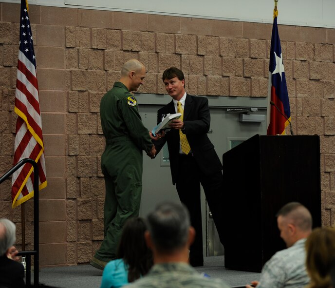 U.S. Air Force Col. Michael Bob Starr, 7th Bomb Wing commander, left, is presented a book about Lt. Col. William Edwin Dyess from Gray Bridwell, Military Affairs Committee March 21, 2014, at the Abilene Civic Center in Abilene, Texas. The quarterly luncheon gives MAC members and Dyess leadership the opportunity to exchange information about upcoming events, activities and issues of mutual interest. (U.S. Air Force photo by Airman 1st Class Alexander Guerrero/Released)