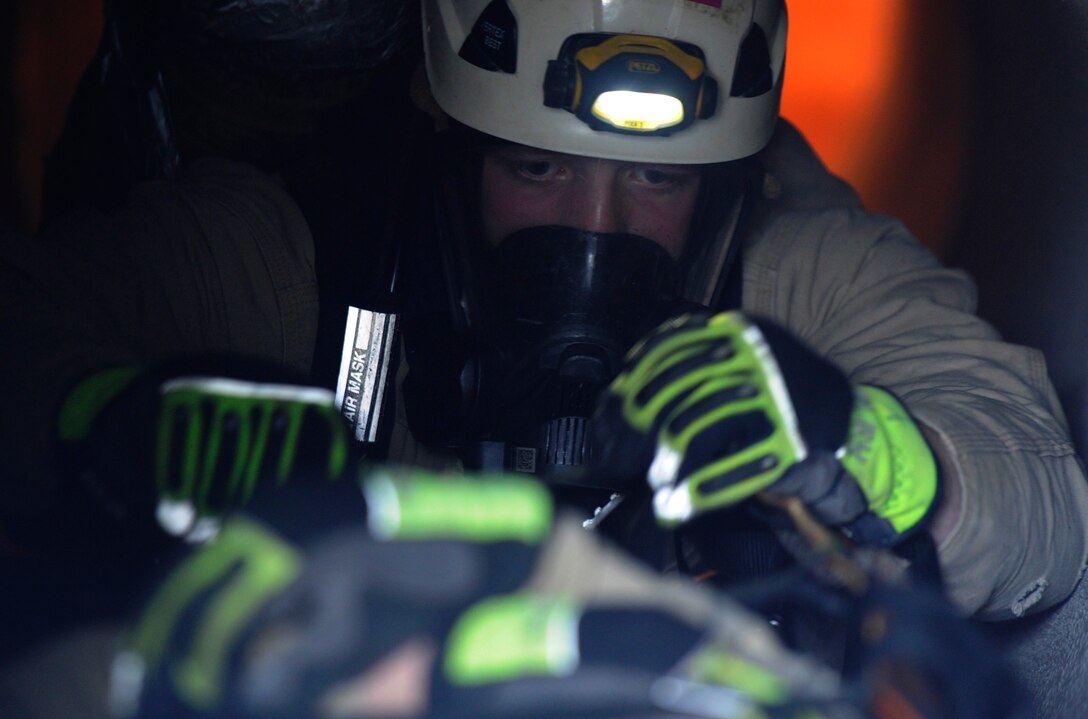 Airman 1st Class Jared Becker, 11th Civil Engineer Squadron firefighter, aids a simulated victim during a fire rescue training scenario at the Fire Training Area on Joint Base Andrews, Md., March 19, 2014. (U.S. Air Force photo/Airman 1st Class Nesha Humes)