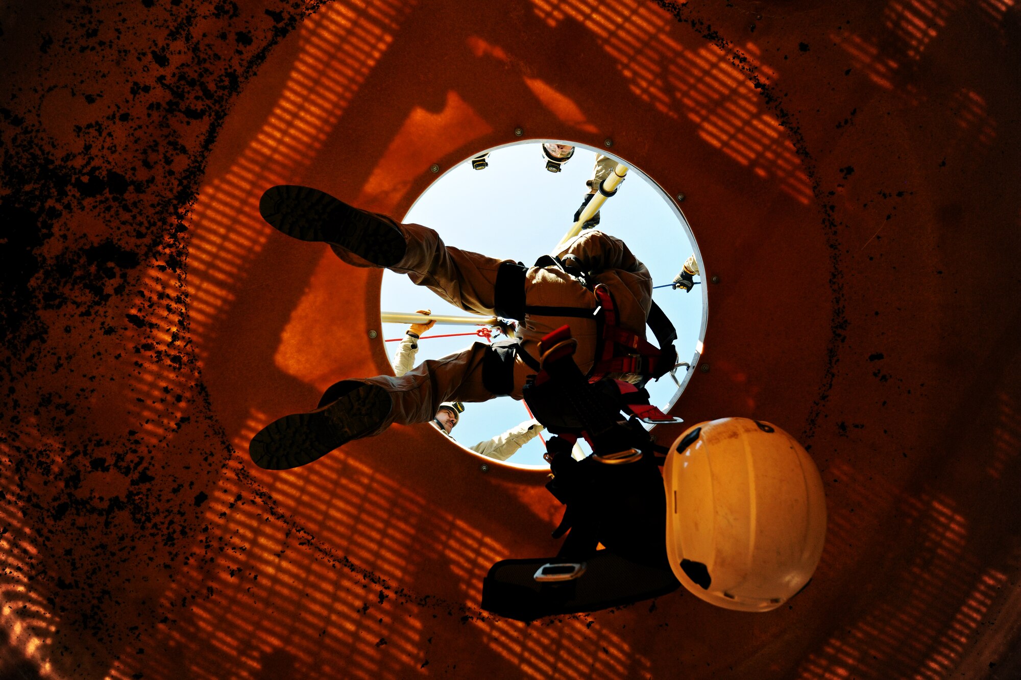 Airman 1st Class Tevin Charles, 11th Civil Engineer Squadron firefighter, lowers himself down into the Fire Training Area vertical confined space trainer during a rescue scenario on Joint Base Andrews, Md., March 20, 2014. (U.S. Air Force photo/Airman 1st Class Nesha Humes)
