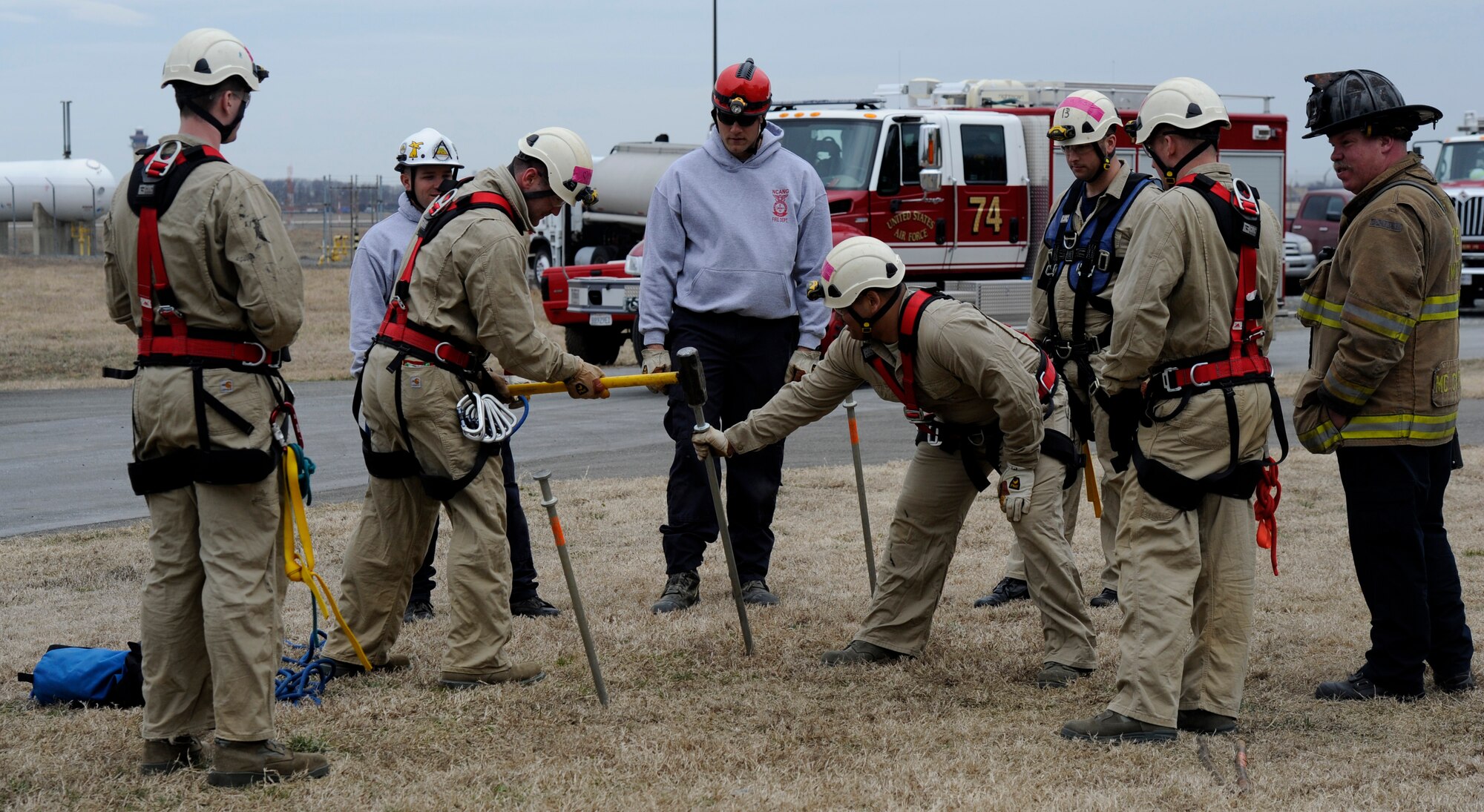Fire Rescue 1 trainees learn to drive a spear into the ground with a sledgehammer to create a three-picket anchor at the Fire Training Area on Joint Base Andrews, Md., March 19, 2014. The interconnected pickets are utilized as an anchor for a rope rescue system. (U.S. Air Force photo/Airman 1st Class Nesha Humes)