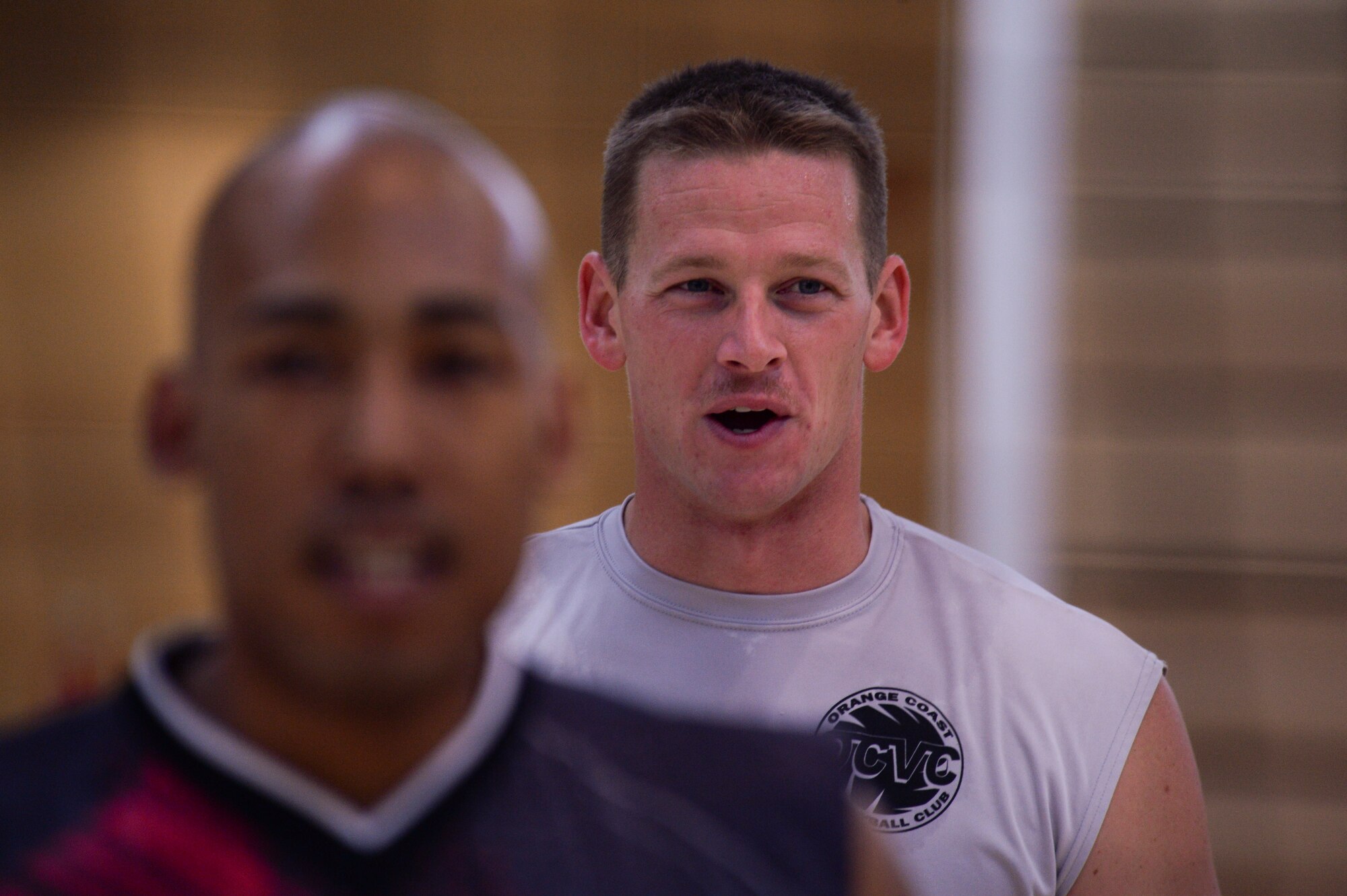 Stuart Sherman, a U.S. Air Forces in Europe and Air Forces Africa men's volleyball team player, grins prior to beginning a drill during the final day of their training camp March 24, 2014, at Spangdahlem Air Base, Germany. Both the men's and women's teams are made of Airmen from U.S. and USAFE bases. (U.S. Air Force photo by Senior Airman Rusty Frank/Released)