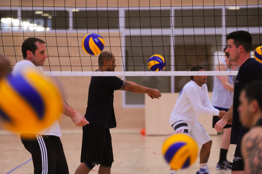 Members from the U.S. Air Forces in Europe and Air Forces Africa men's volleyball team, warm up during day three of their training camp March 23, 2014, at Spangdahlem Air Base, Germany. The men's team consists of 12 all active-duty Air Force members. (U.S. Air Force photo by Senior Airman Rusty Frank/Released)