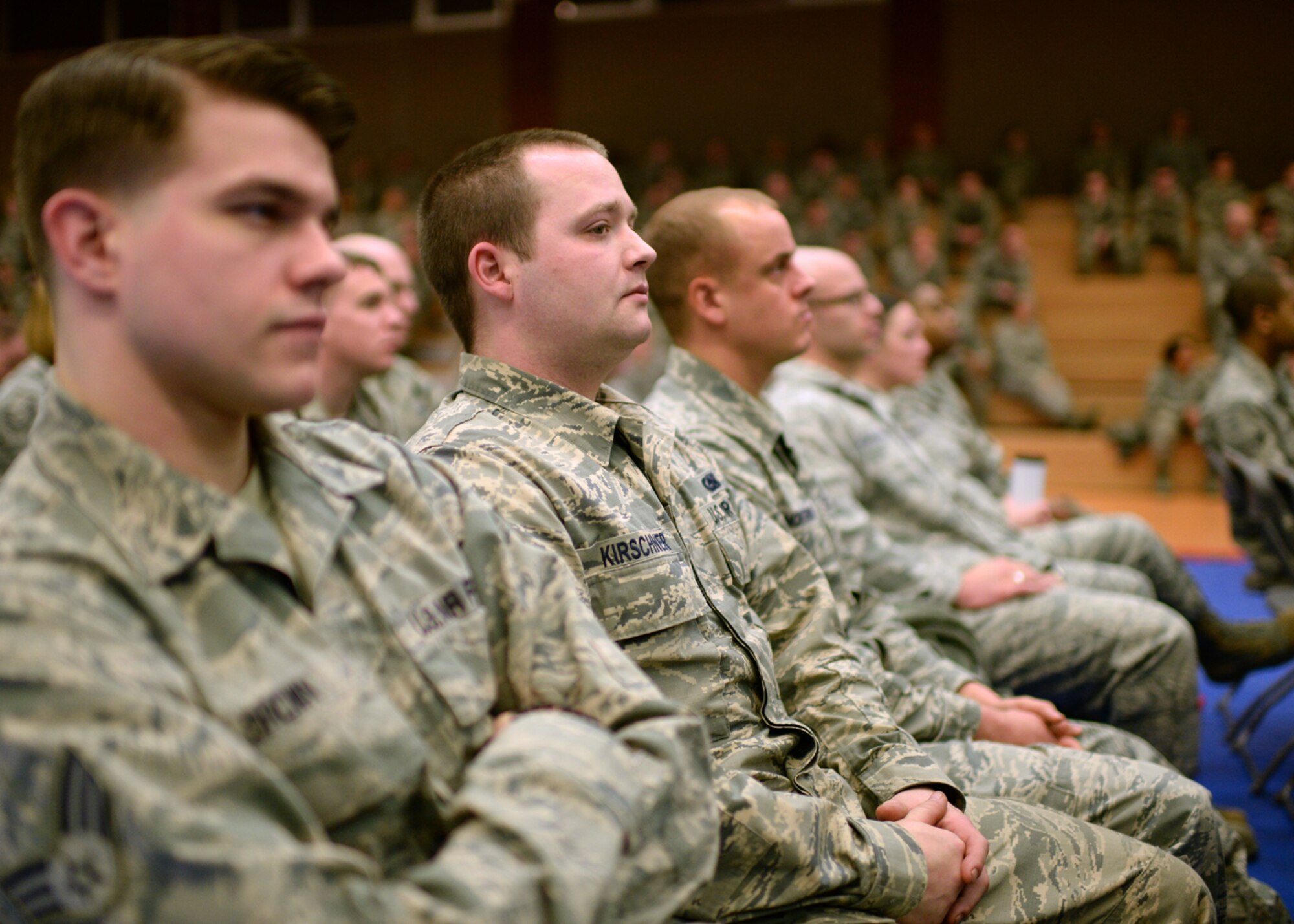 U.S. Air Force Senior Airman Cody Kirschner, 52nd Logistics Readiness Squadron and native of Fort Worth, Texas, listens to 52nd Fighter Wing leadership during a mass briefing in the Skelton Memorial Fitness Center at Spangdahlem Air Base, Germany, March 26, 2014. This commander’s call specifically targeted Spangdahlem Air Base's enlisted corps with topics ranging from force management to budget concerns. (U.S. Air Force photo by Staff Sgt. Daryl Knee/Released)
