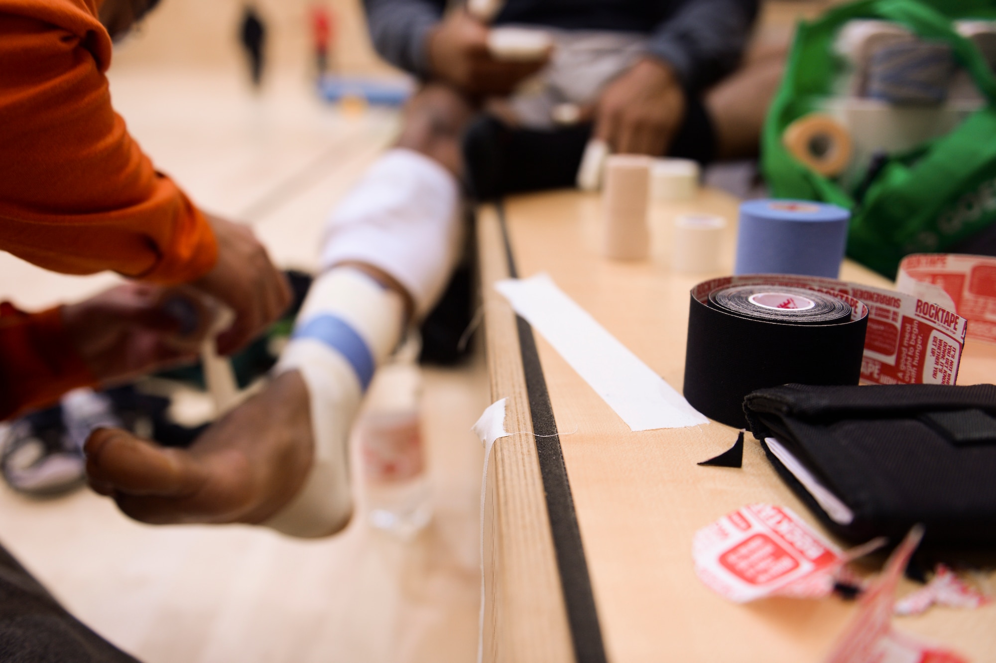 Medical tape is set out as U.S. Air Force Maj. Jeffrey Sabido, a 52nd Medical Group physician’s assistant from Guam, tapes up a player from the U.S. Air Forces in Europe and Air Forces Africa men's volleyball team March 22, 2014, at Spangdahlem Air Base, Germany. The men's team won the bronze medal twice during previous years’ Headquarters Allied Air Command Inter-Nation Sports Programme Volleyball Championships. (U.S. Air Force photo by Senior Airman Rusty Frank/Released)