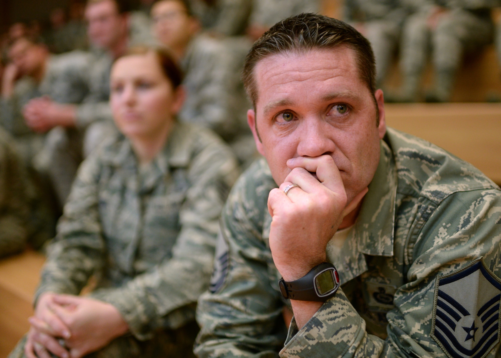 U.S. Air Force Master Sgt. Mark Miller, 52nd Operations Support Squadron and native of Grand Prairie, Texas, listens to base leadership during a mass briefing in the Skelton Memorial Fitness Center at Spangdahlem Air Base, Germany, March 26, 2014. The 52nd Fighter Wing leadership conducts briefings, or commander’s calls, throughout the year to inform Airmen of events such as upcoming base construction projects or force reshaping. (U.S. Air Force photo by Staff Sgt. Daryl Knee/Released)